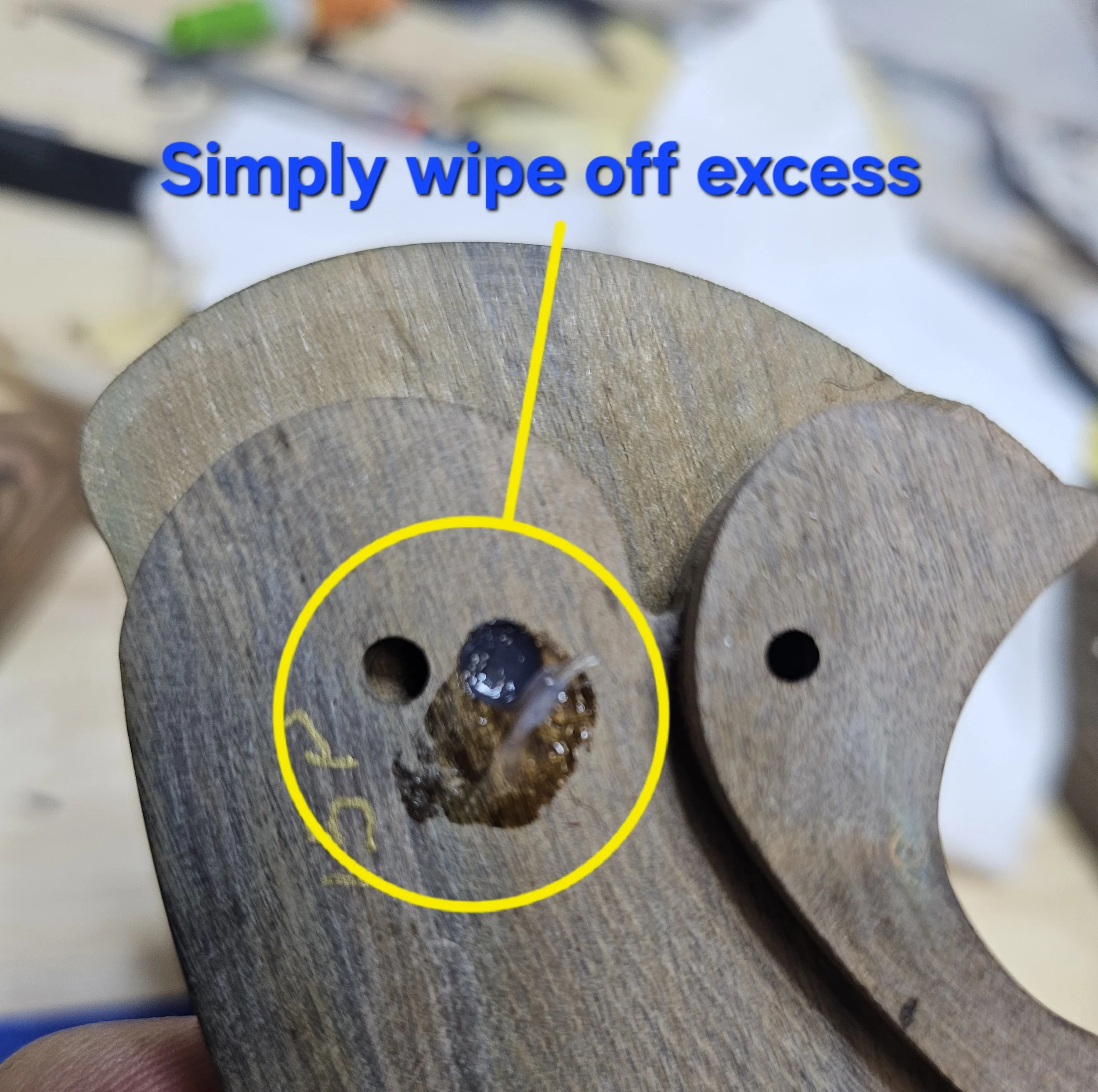 Close-up image of a wooden object, with text in blue saying 'Simply wipe off excess' overlaid on top.