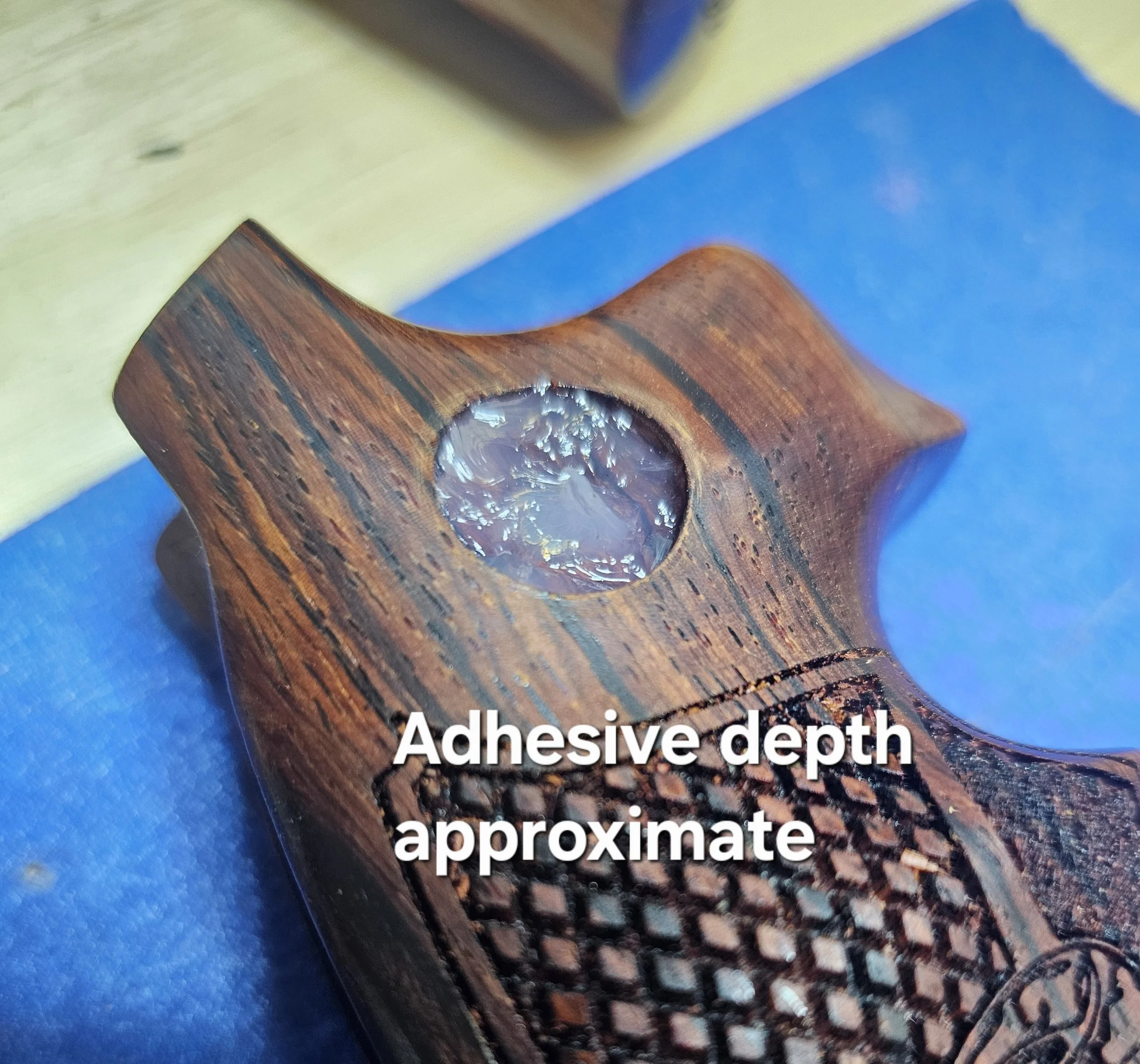 Close-up view of a wooden object with a drilled hole showing shiny, metallic reinforcement inside.