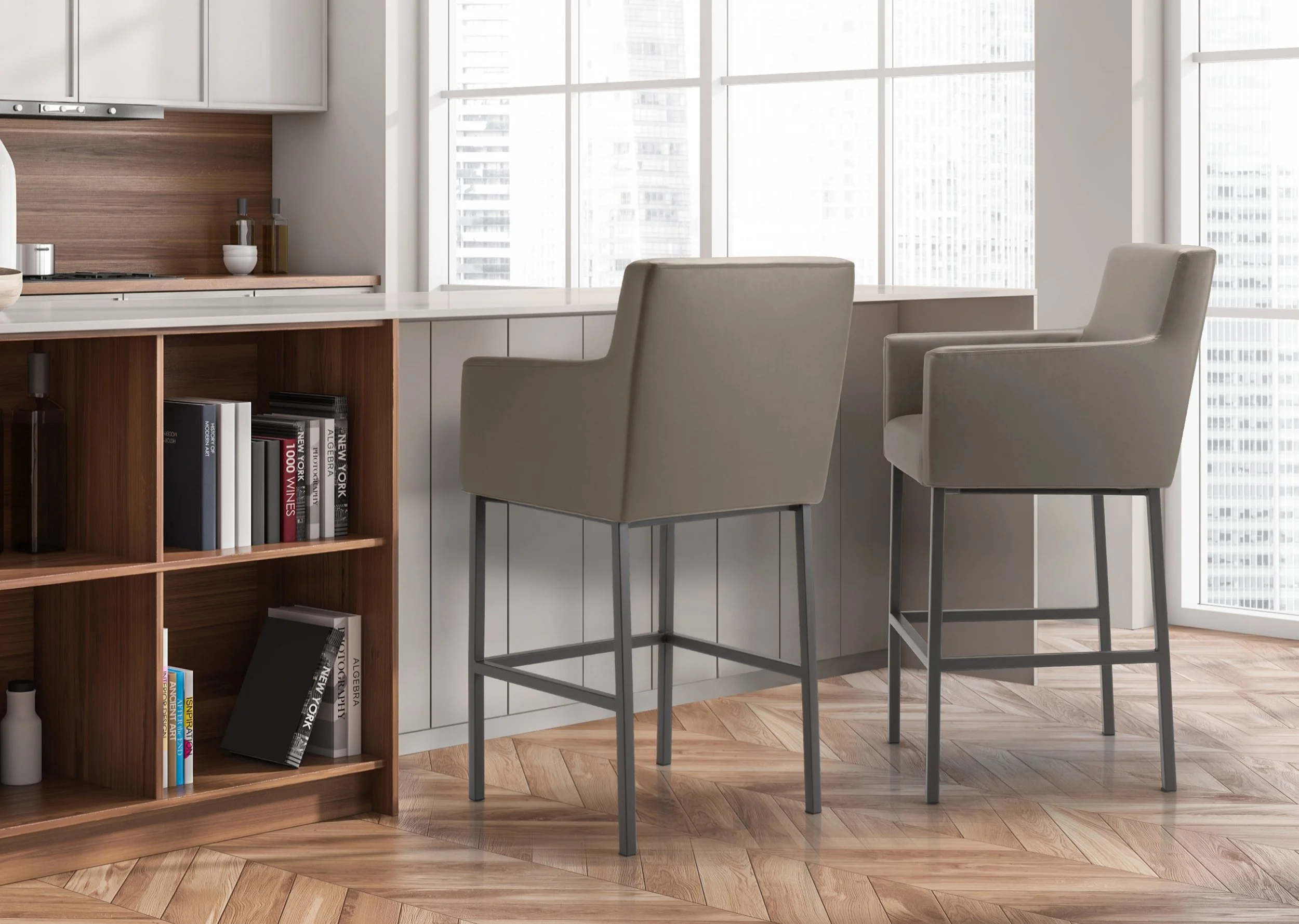 Modern kitchen with two beige barstools at a white counter, wooden bookshelf with books on the left, large windows with city view in the background, and a hardwood floor.