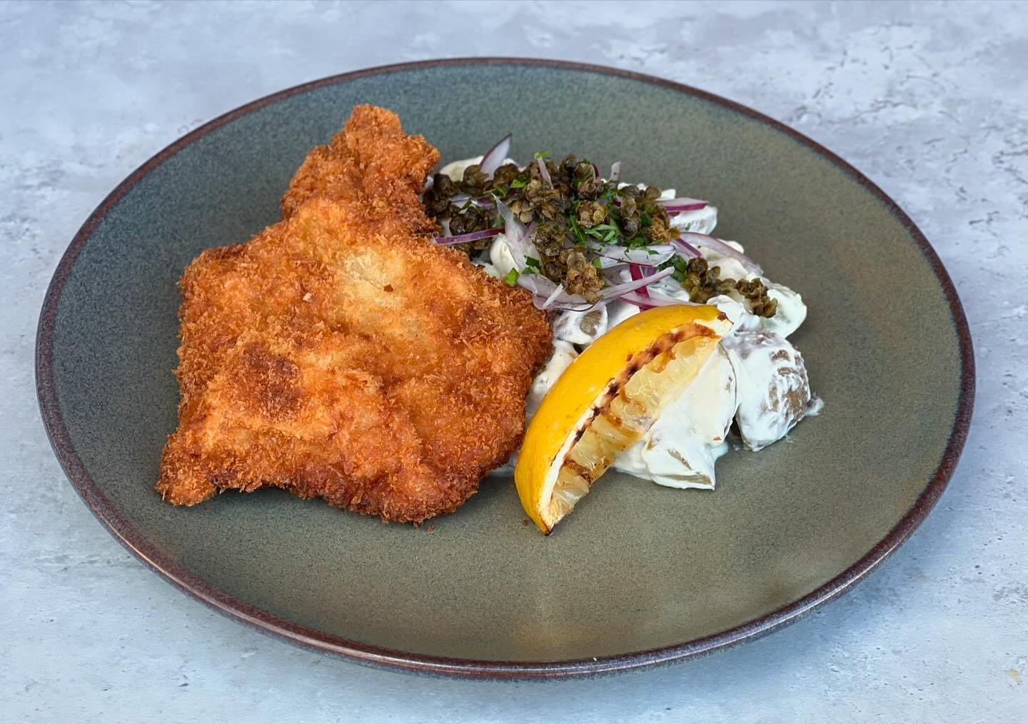Schnitzel med grillad citron, friterad kapris, r&ouml;dl&ouml;k och kr&auml;mig potatissallad