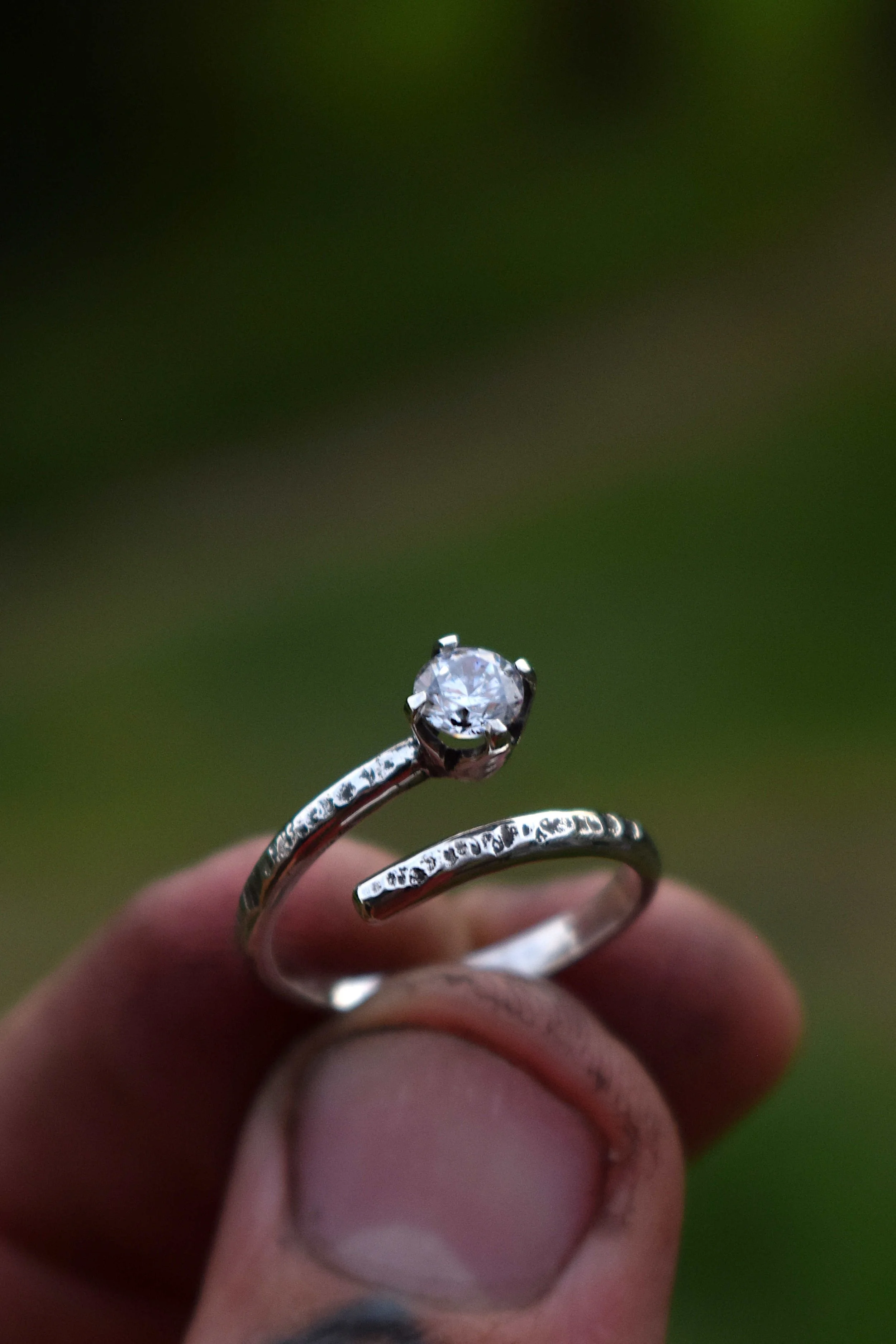 A handmade sterling silver ring, set with a clear, White gemstone