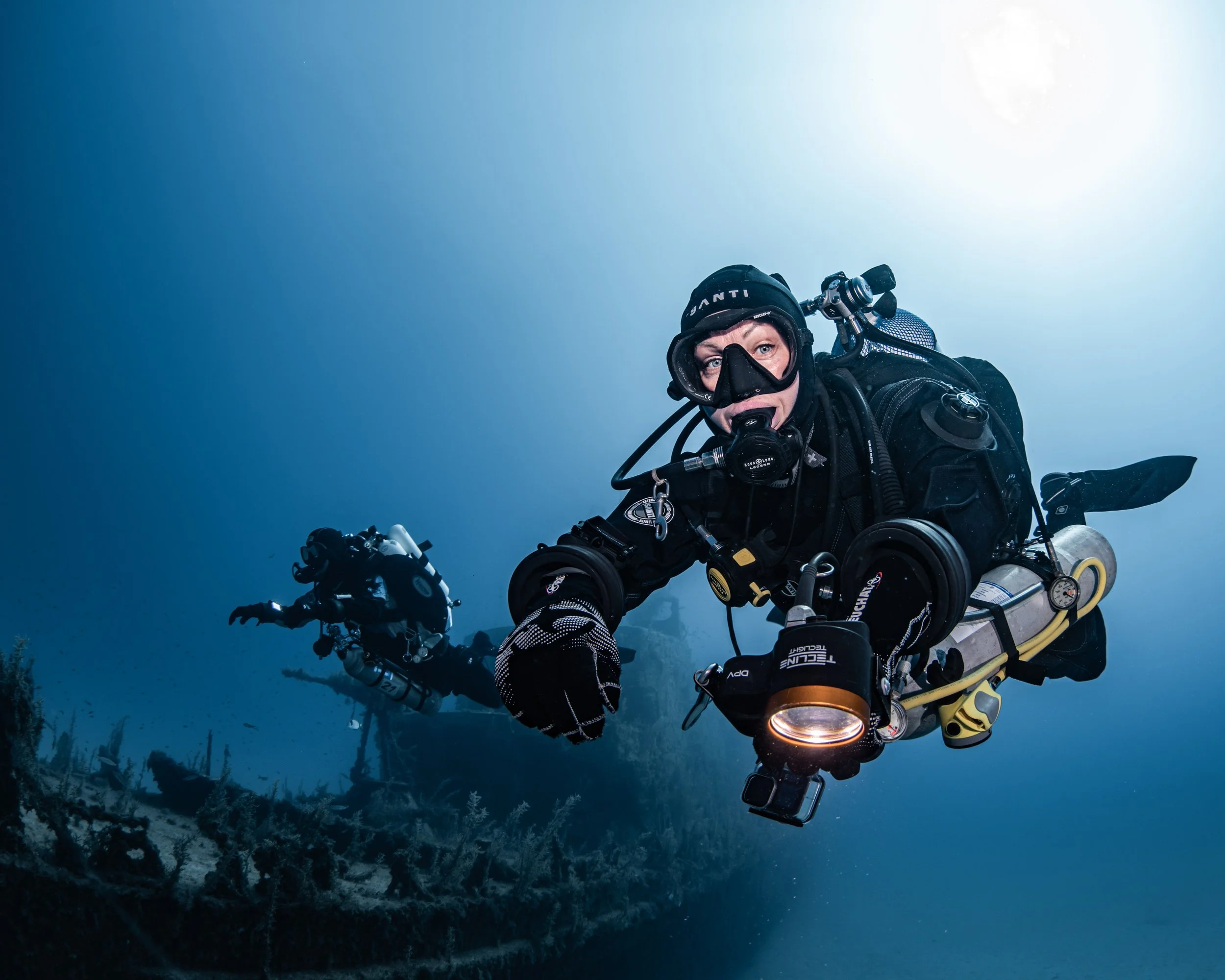 Two technical divers leaving a shipwreck and beginning their ascent.