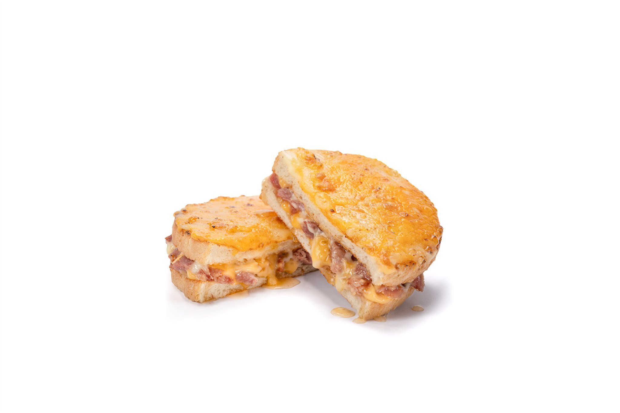 Close-up of a grilled cheese sandwich with ham and melted cheese, cut in half and placed on a white background.