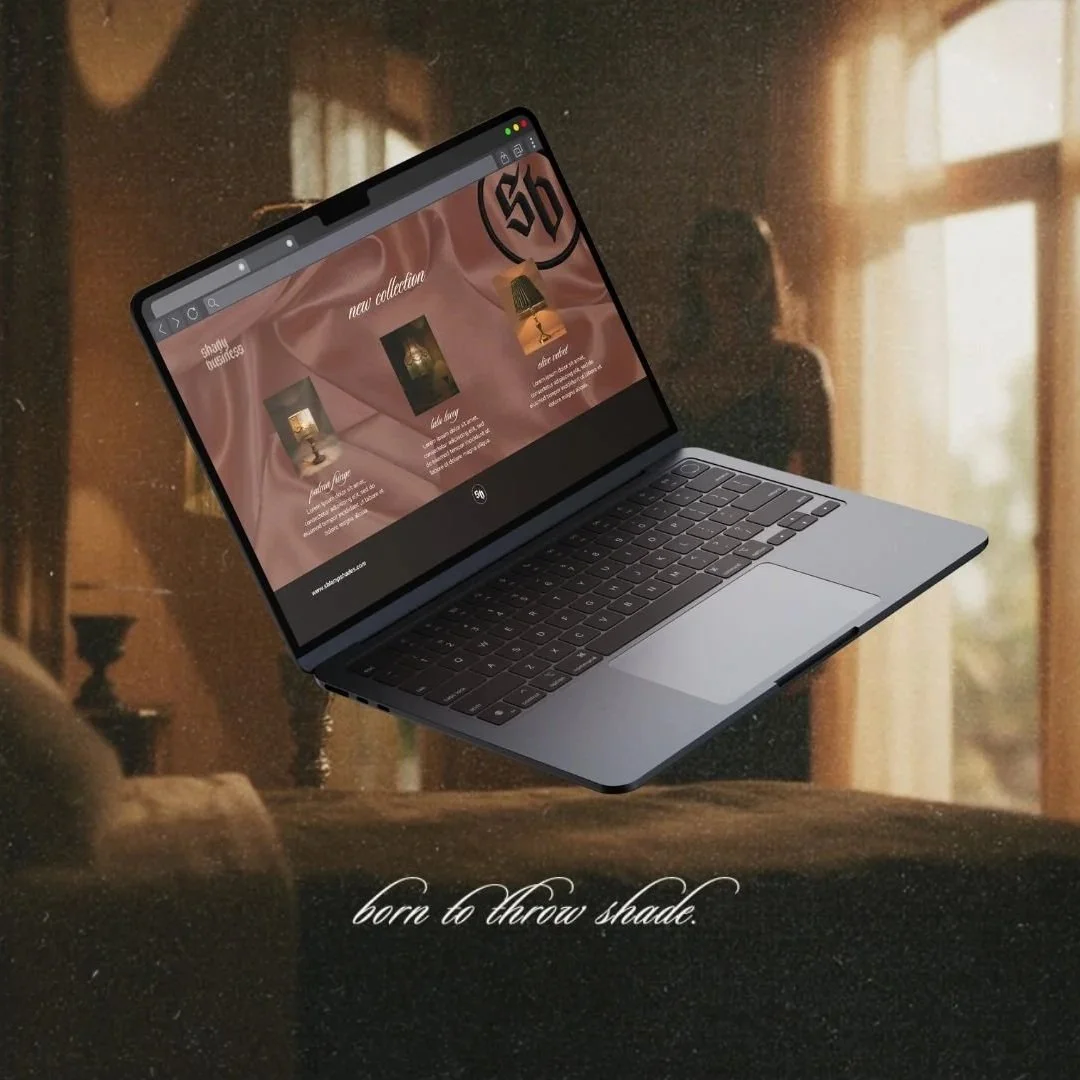 A silver laptop floating in a dimly lit room with sunlight coming through the window. The laptop screen displays a website with some products and the text "born to throw shade" is written at the bottom of the image.