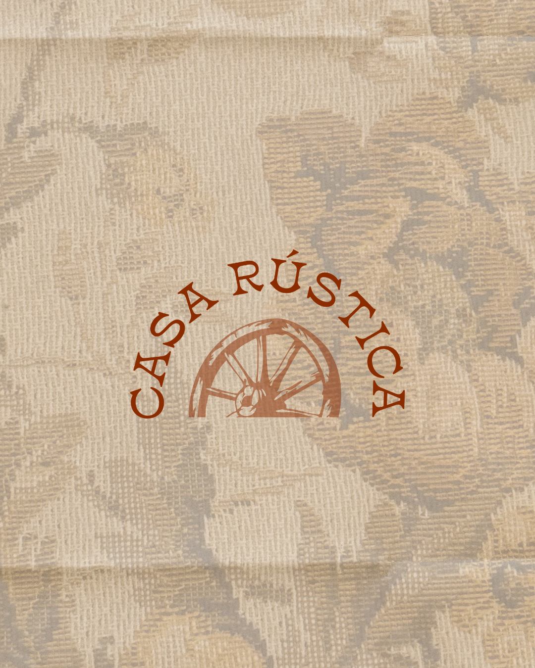 A beige paper bag with a logo of a wagon wheel and the words "Casa Rústica" printed in brown.