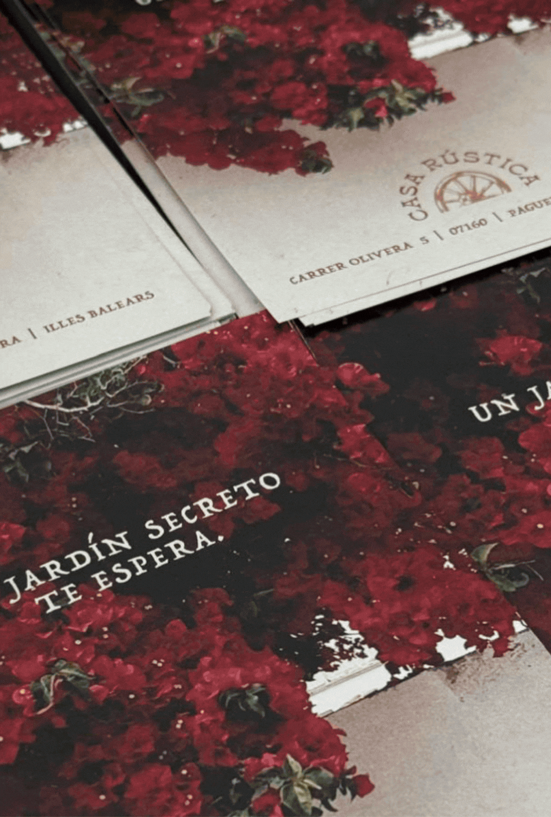 A close-up of a floral-themed menu or sign with Spanish text, including "Jardín Secreto Teatro" and other words, on a surface with a red and black floral pattern.