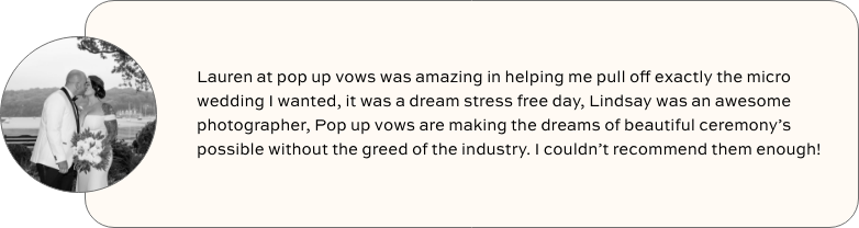 Black and white photo of a couple with a flower bouquet, sharing a kiss outdoors.