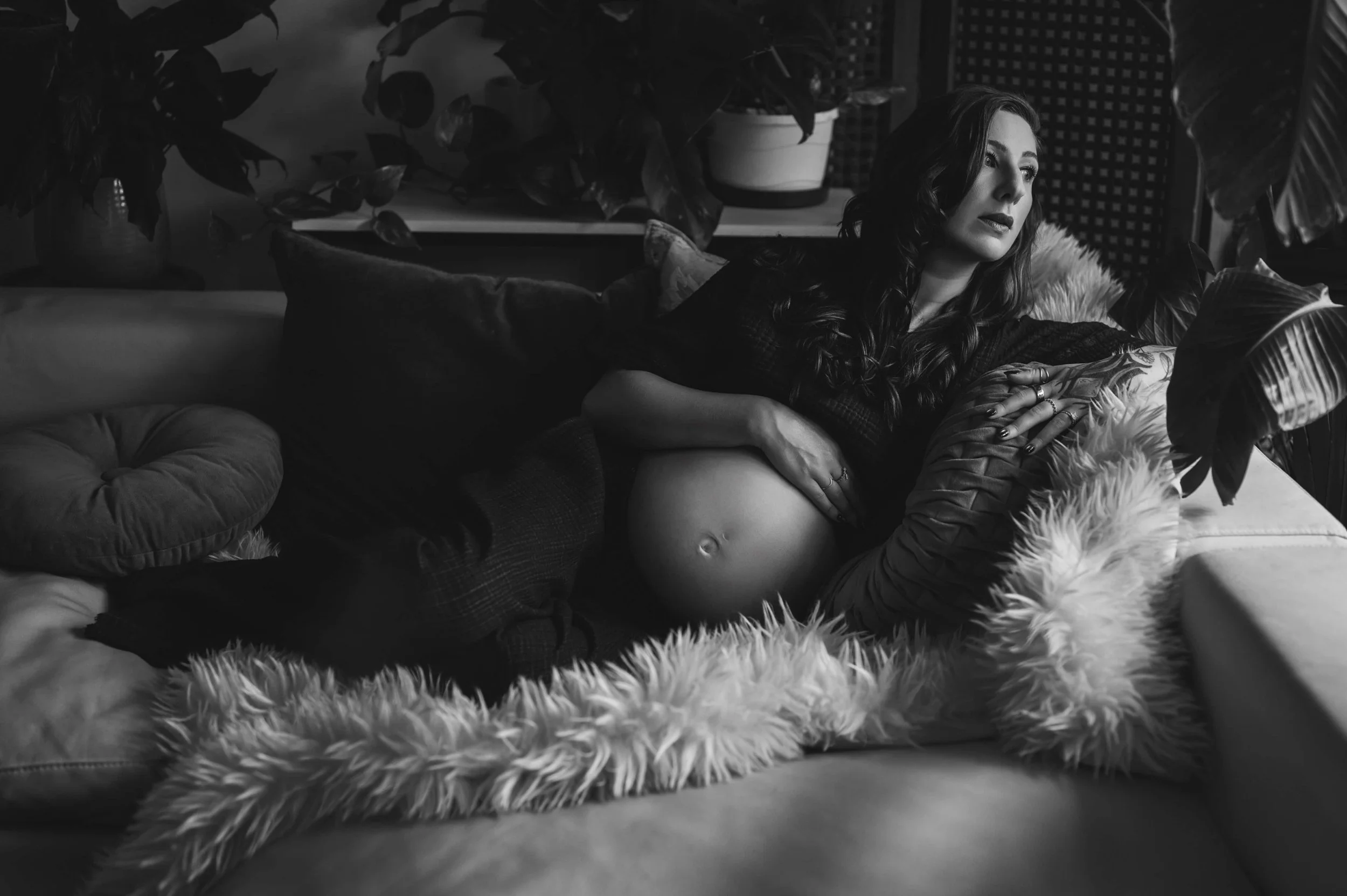 Intimate studio maternity portrait captured in black and white natural light