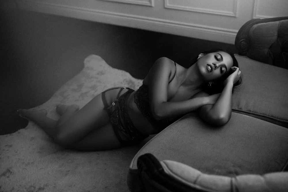 black and white image of woman posing on couch