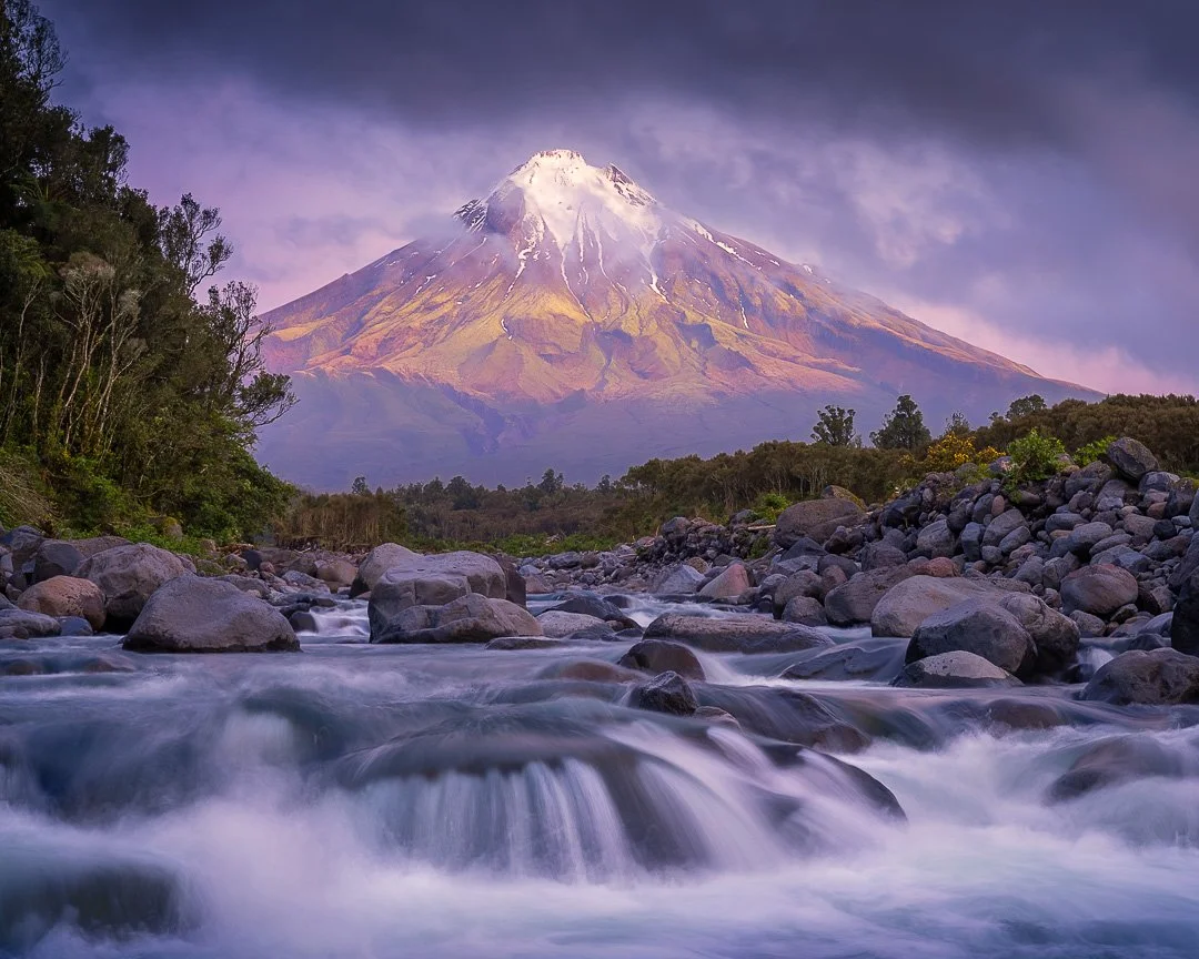 Unveiling the Maunga - Taranaki, NZ.

After an evening of waiting and fading light, I had packed away my gear and turned to leave. Then, in one perfect moment, the clouds lifted. Taranaki Maunga stood revealed, glowing softly above the Stony River &m