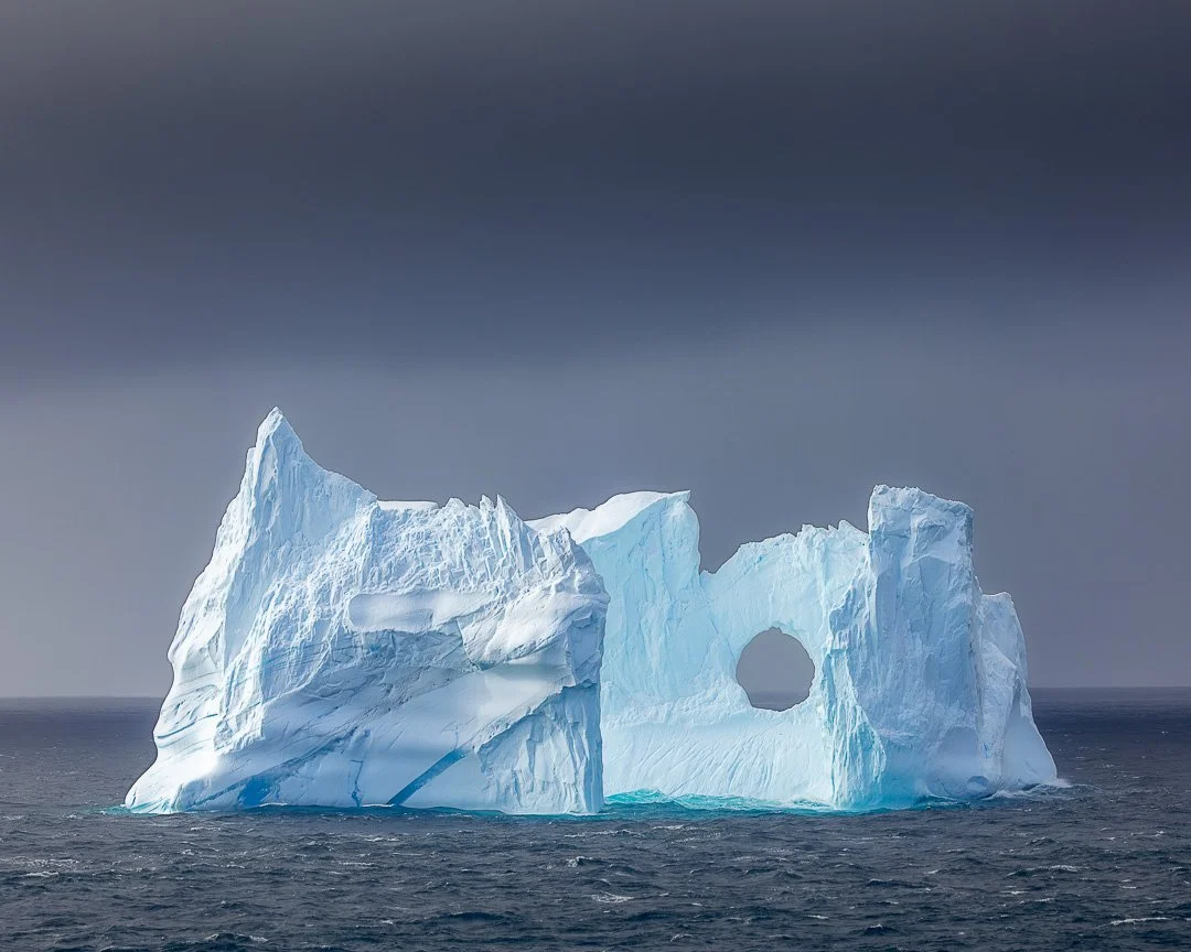 Monoliths Adrift &mdash; Balleny Islands, Antarctica

Ice moves differently here.
Slow. Indifferent. Unseen currents carrying forms the size of houses &mdash; sometimes entire city blocks.

From a moving ship, nothing stays still.
Light shifts. Edges