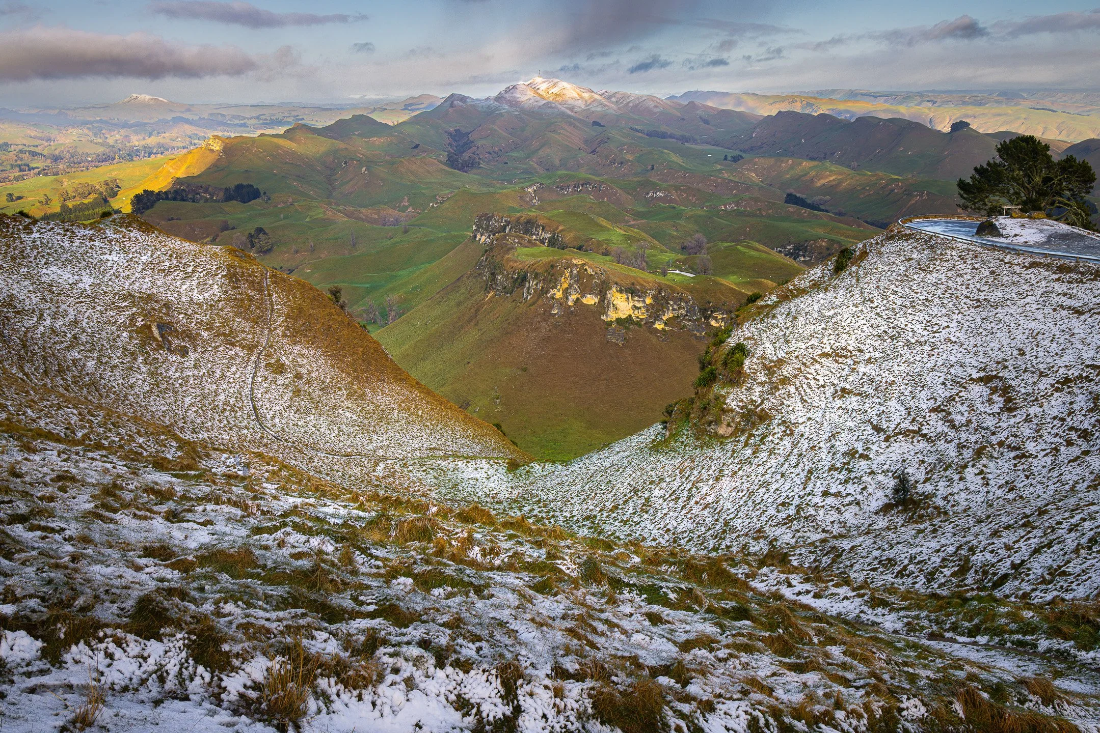 Snow-covered valley on Te Mata Peak with snow-capped Mount Erin visible in the far distance.