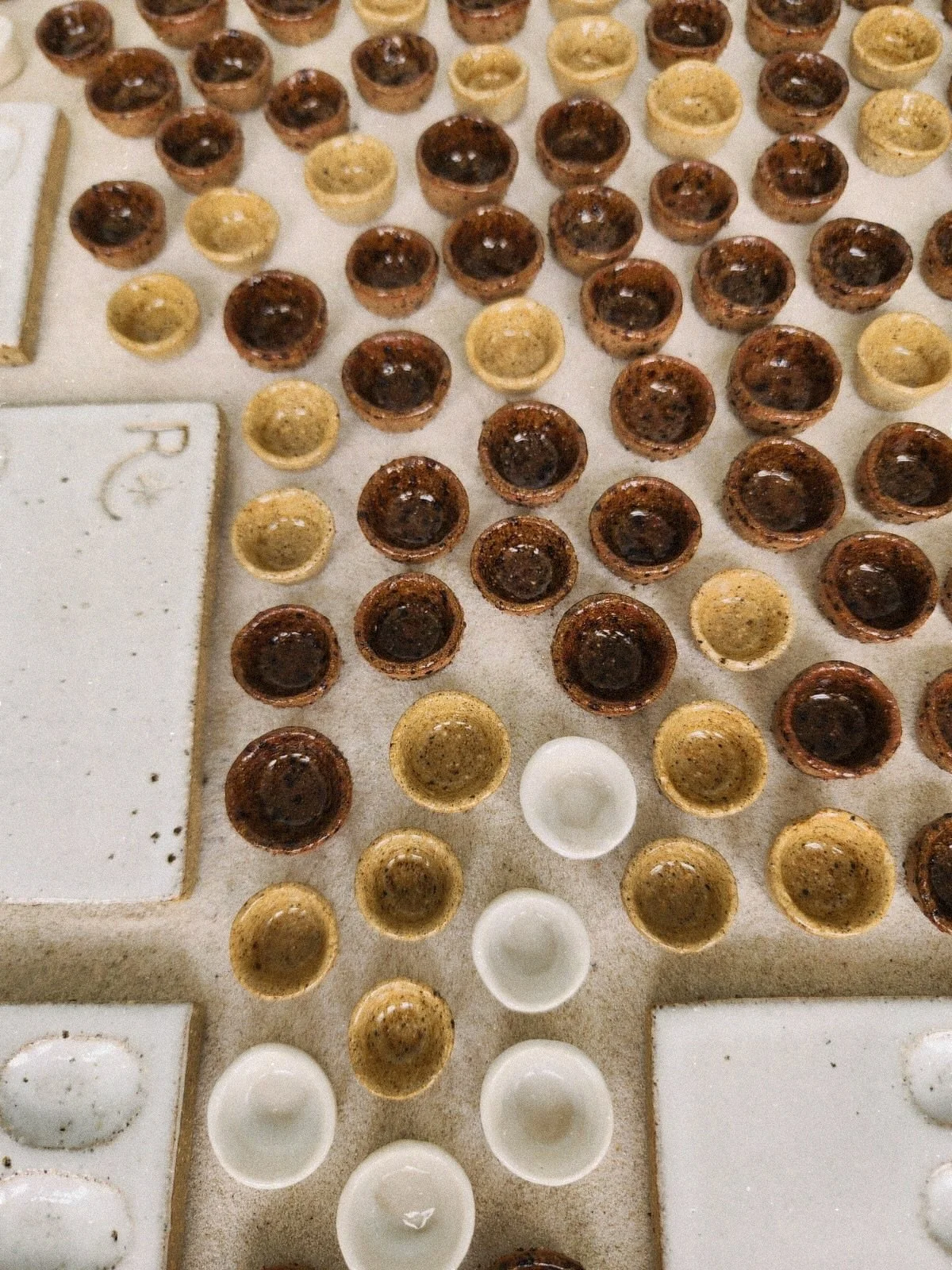 BTS of my little ceramics coming out of their glaze firing 🫶🏻 

5 things I always get asked about this process: 
✨ yes, we make every single palette and each little paint pot from clay in the studio 
🤍 clay is fired twice before it is ceramic once