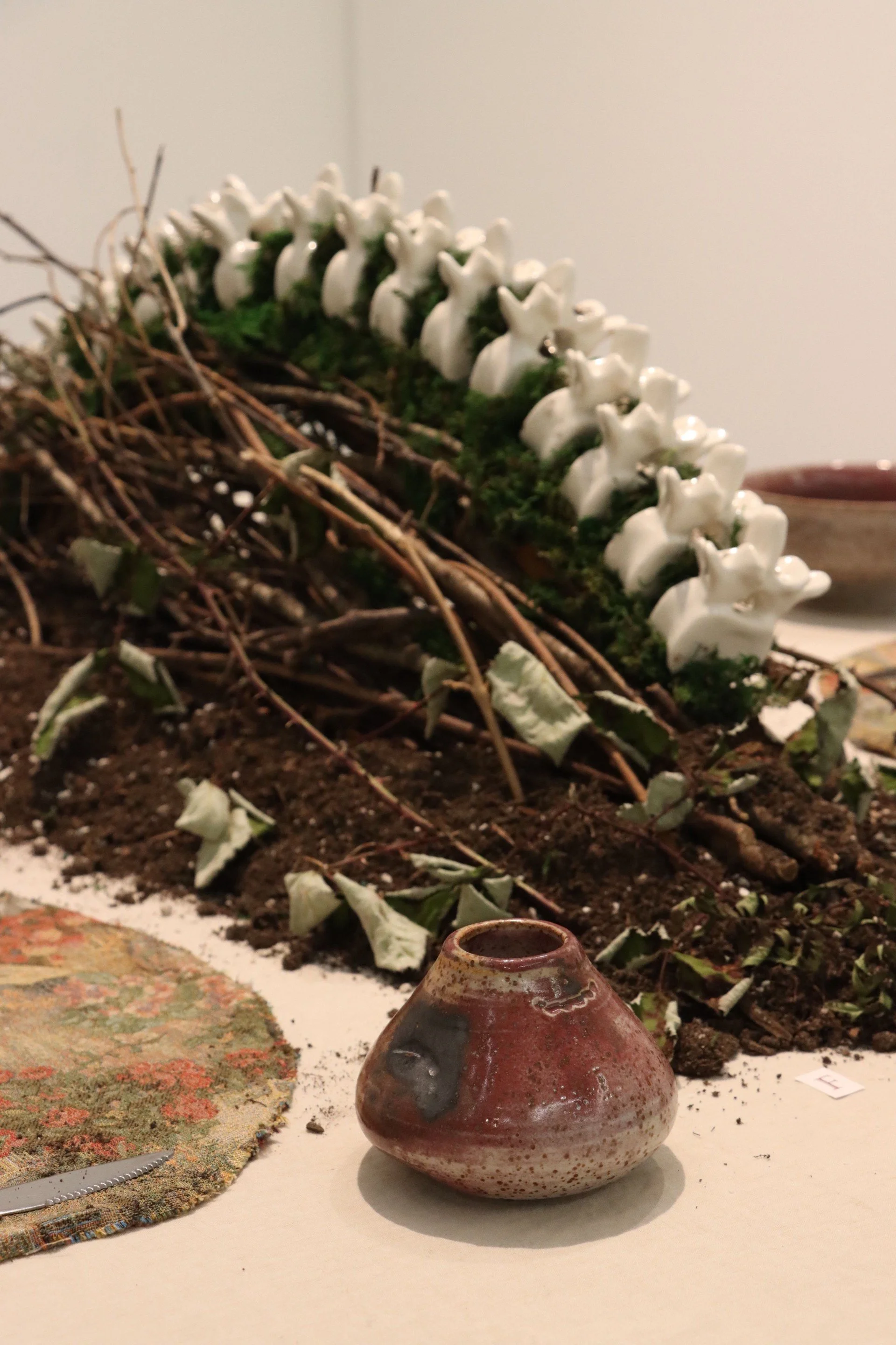 Axel Winterburn, "Untitled, slipcast ceramics, dirt, moss, blackberry thorns (background), Oliver Rinne, "gnawing", wheel thrown and bitten ceramics, various sizes. 