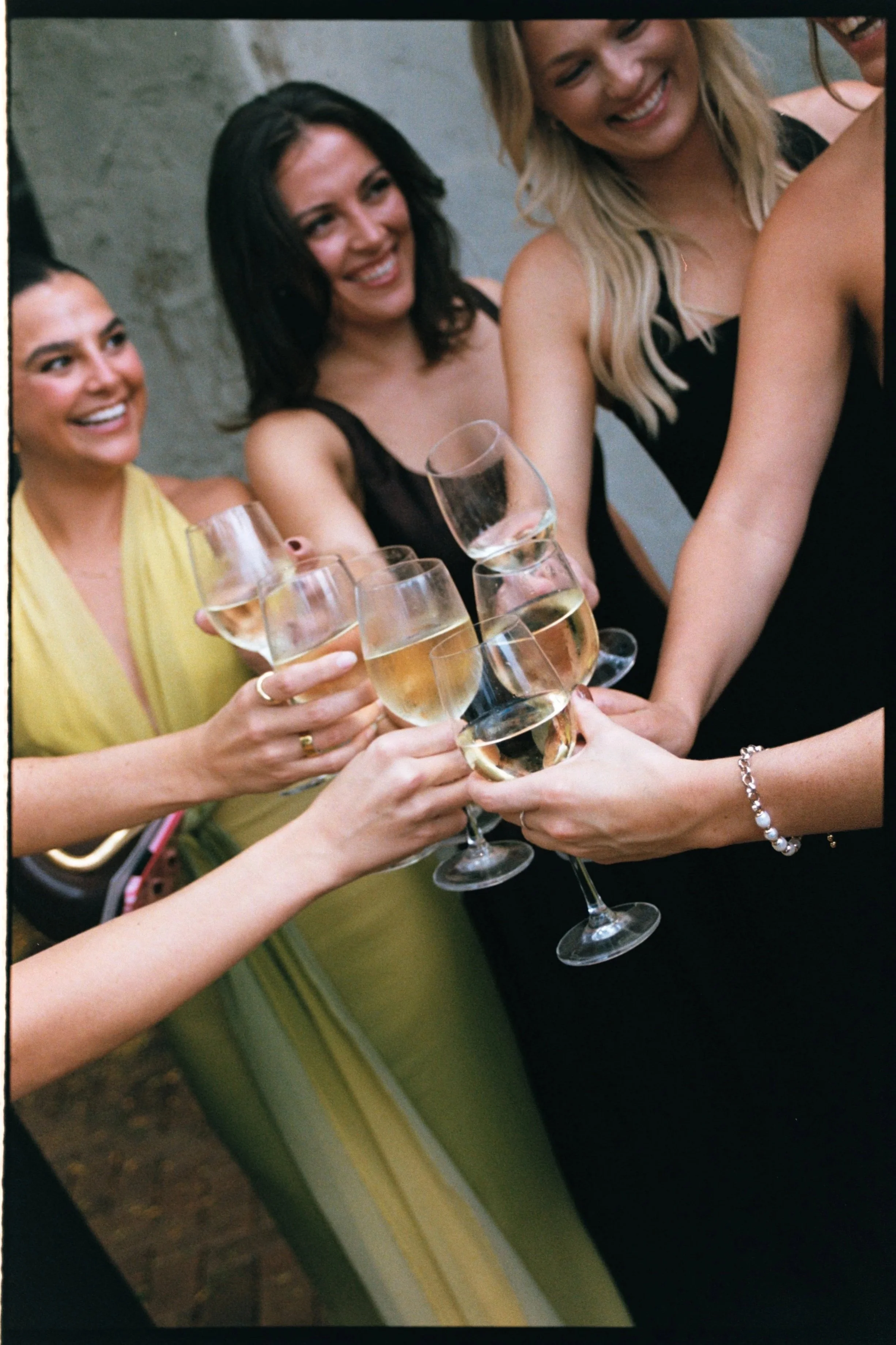 A group of women celebrating by clinking glasses of champagne.