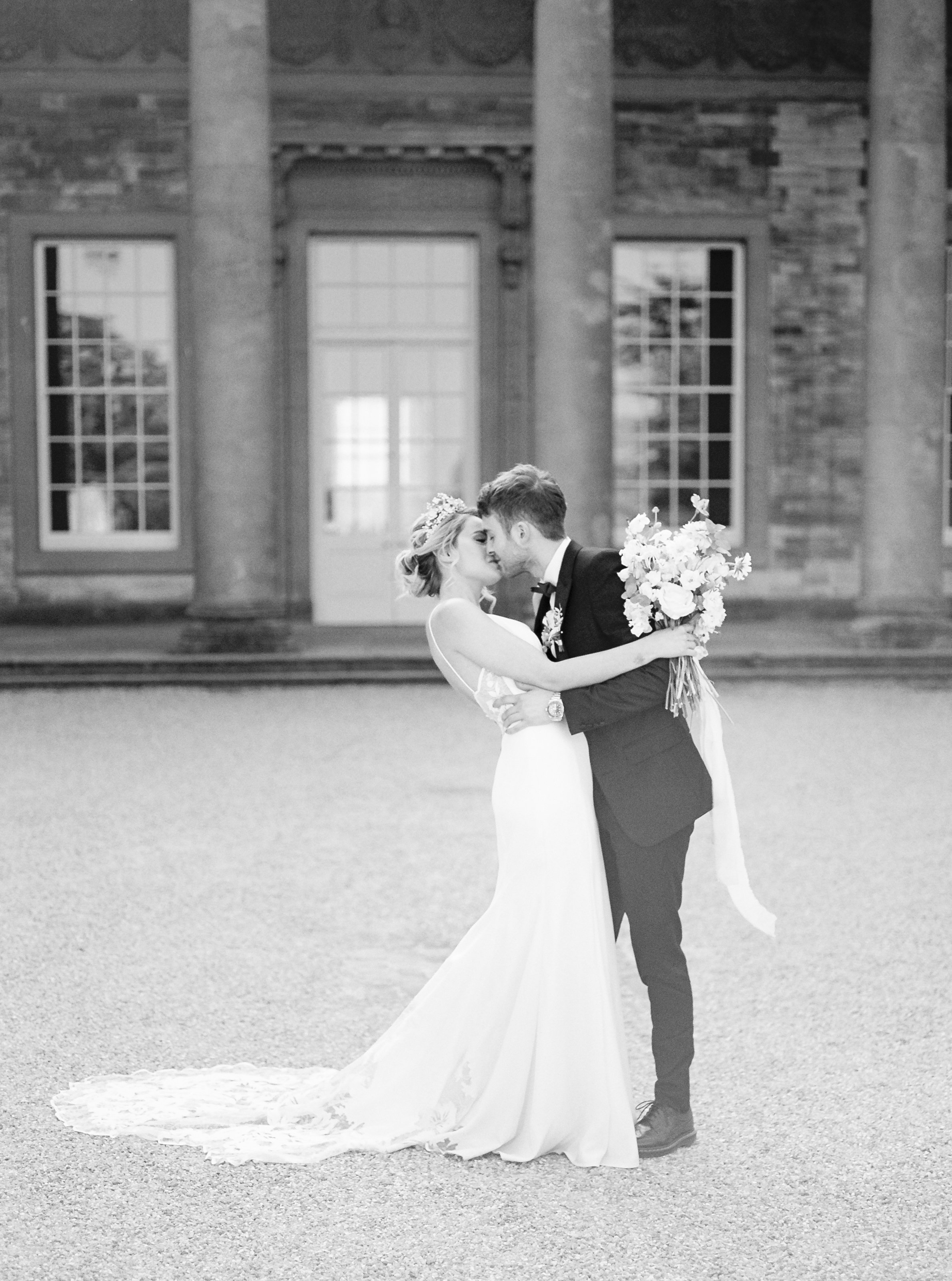 Bride and Groom kissing outside Compton Verney
