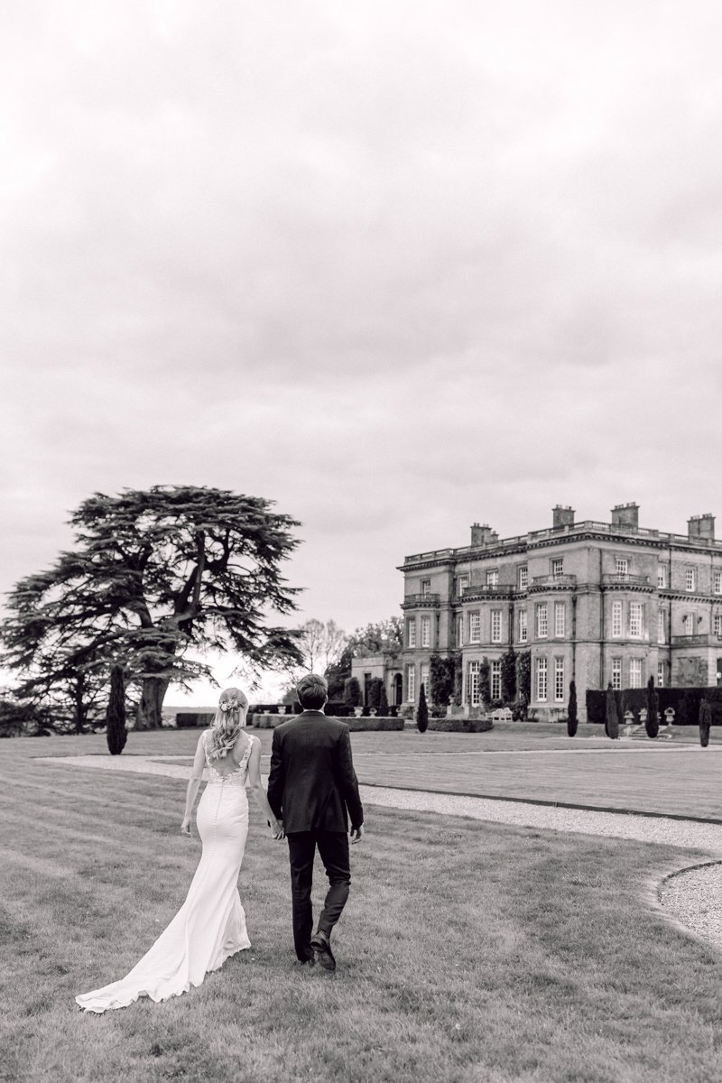 bride and grooming walking outside Hedsor House