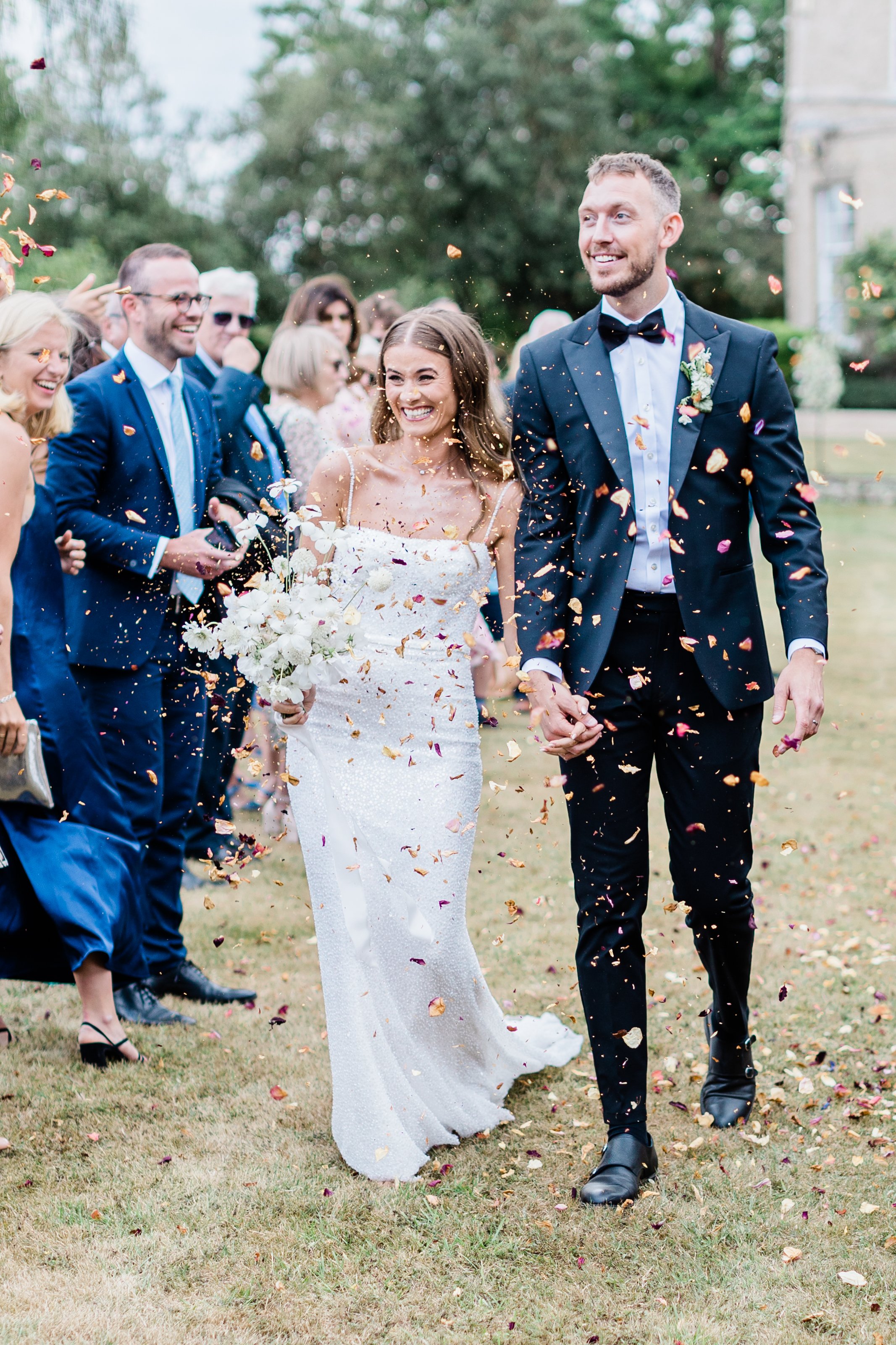 Bride and Groom walking with confetti