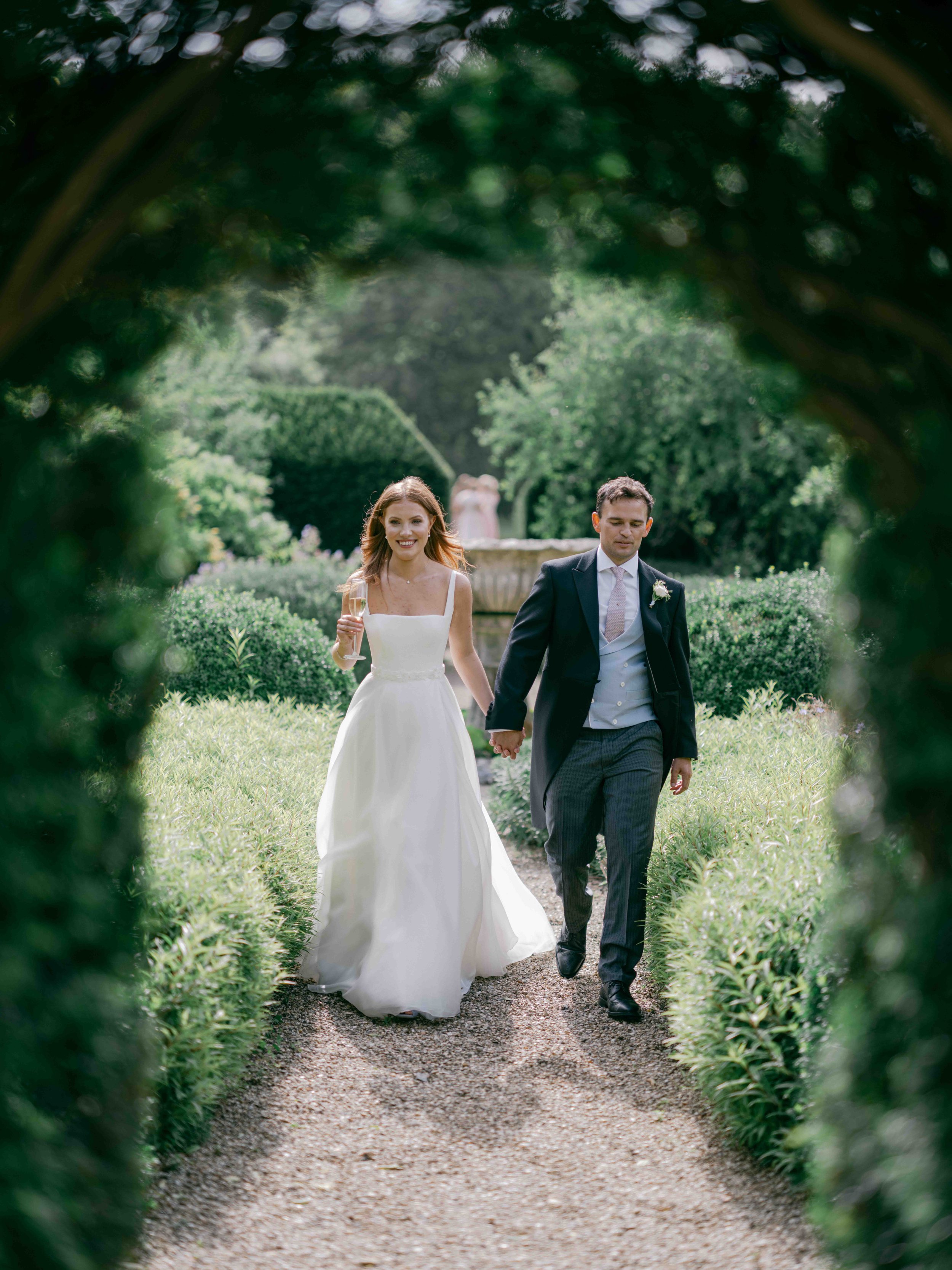  Bride and Groom walking through the gardens at Came House 
