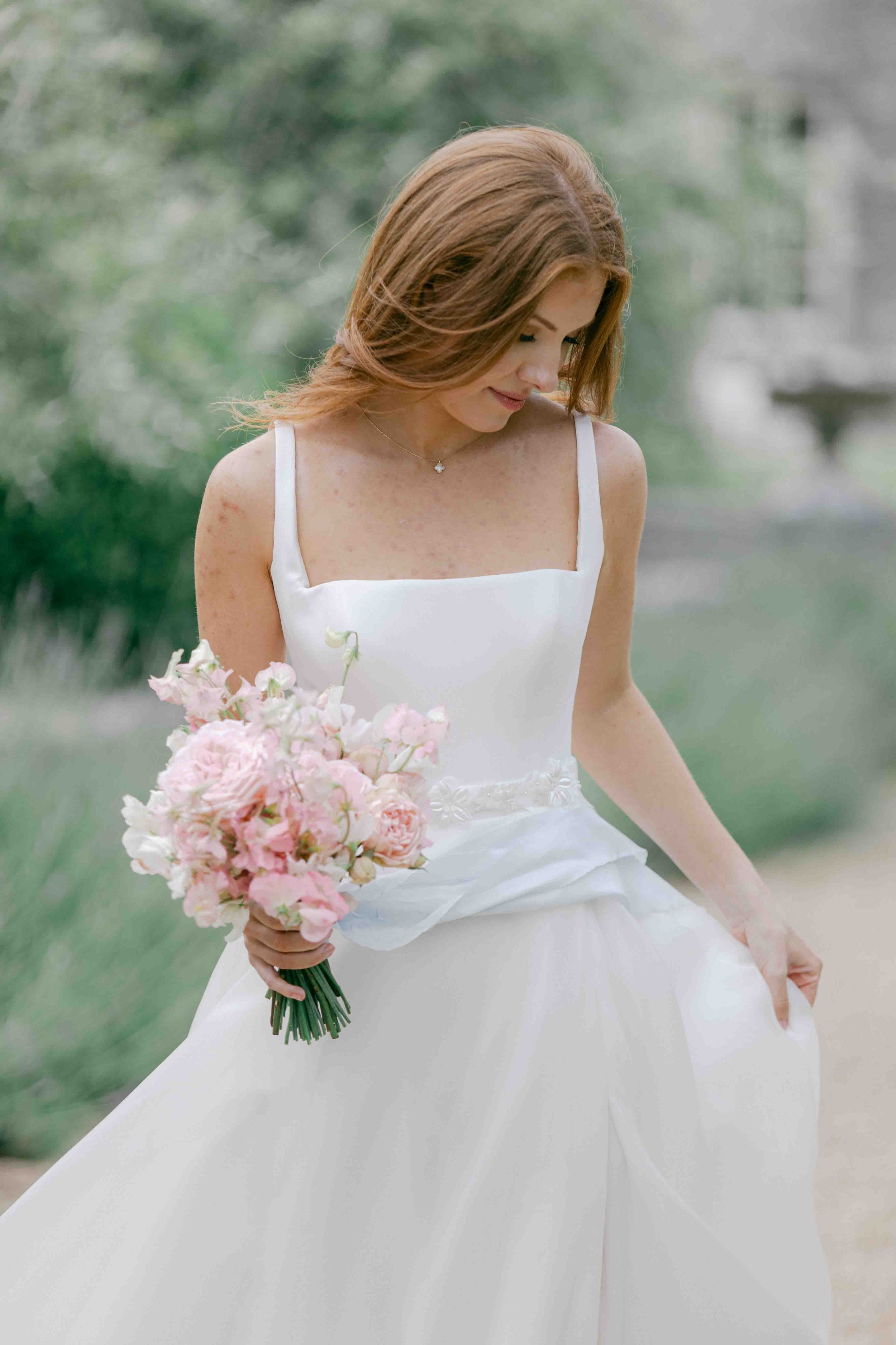  bride holding dress and flower bouquet 