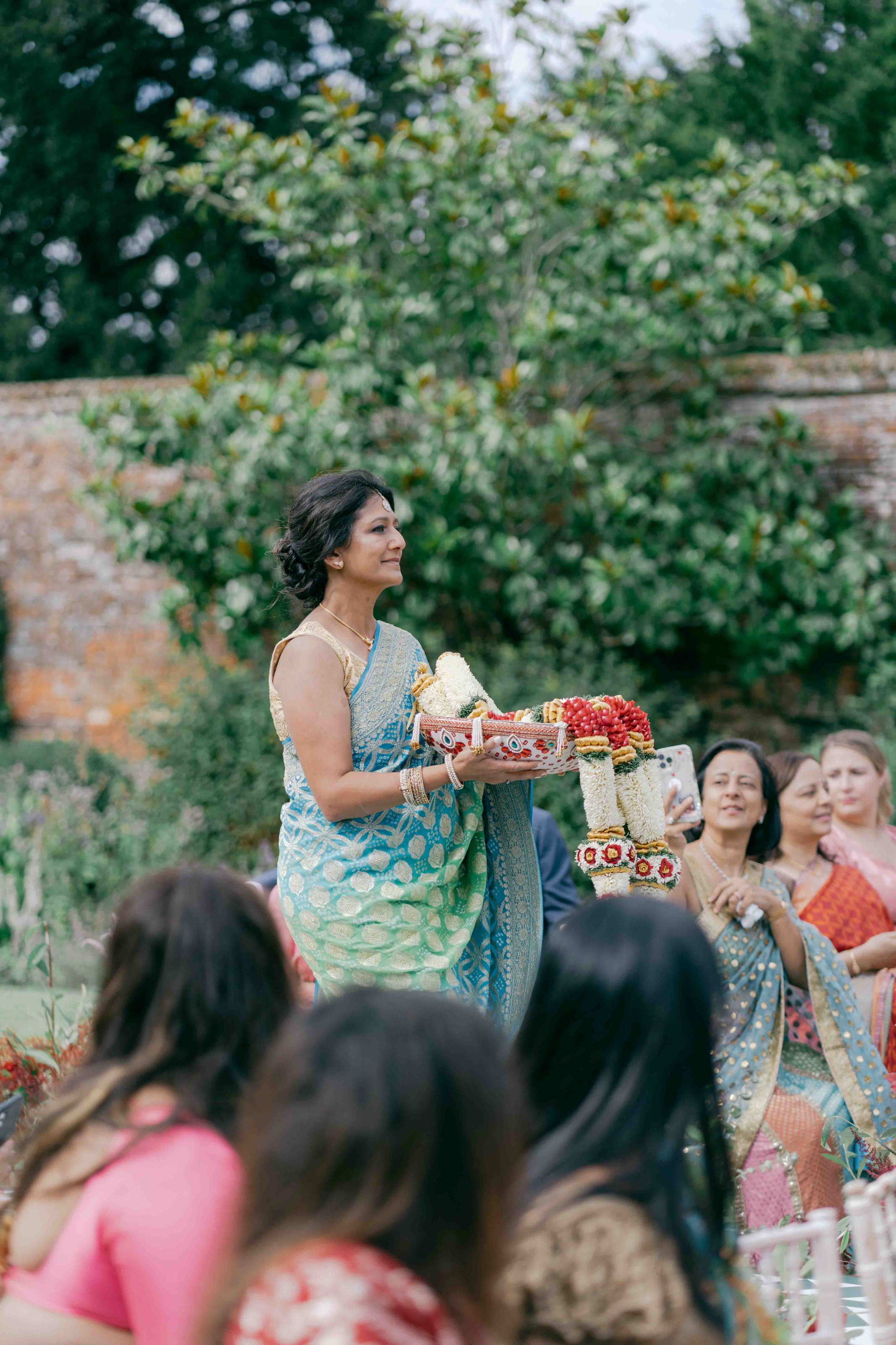  lady walking down the aisle with flower garlands 
