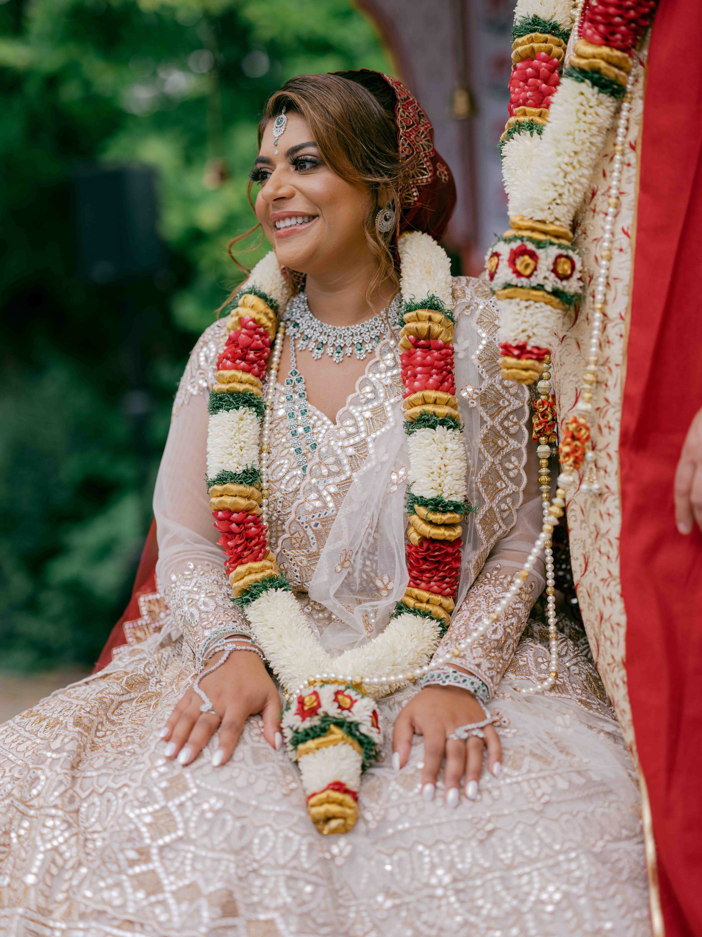  bride smiling wearing flower garland and looking at to her wedding guests 