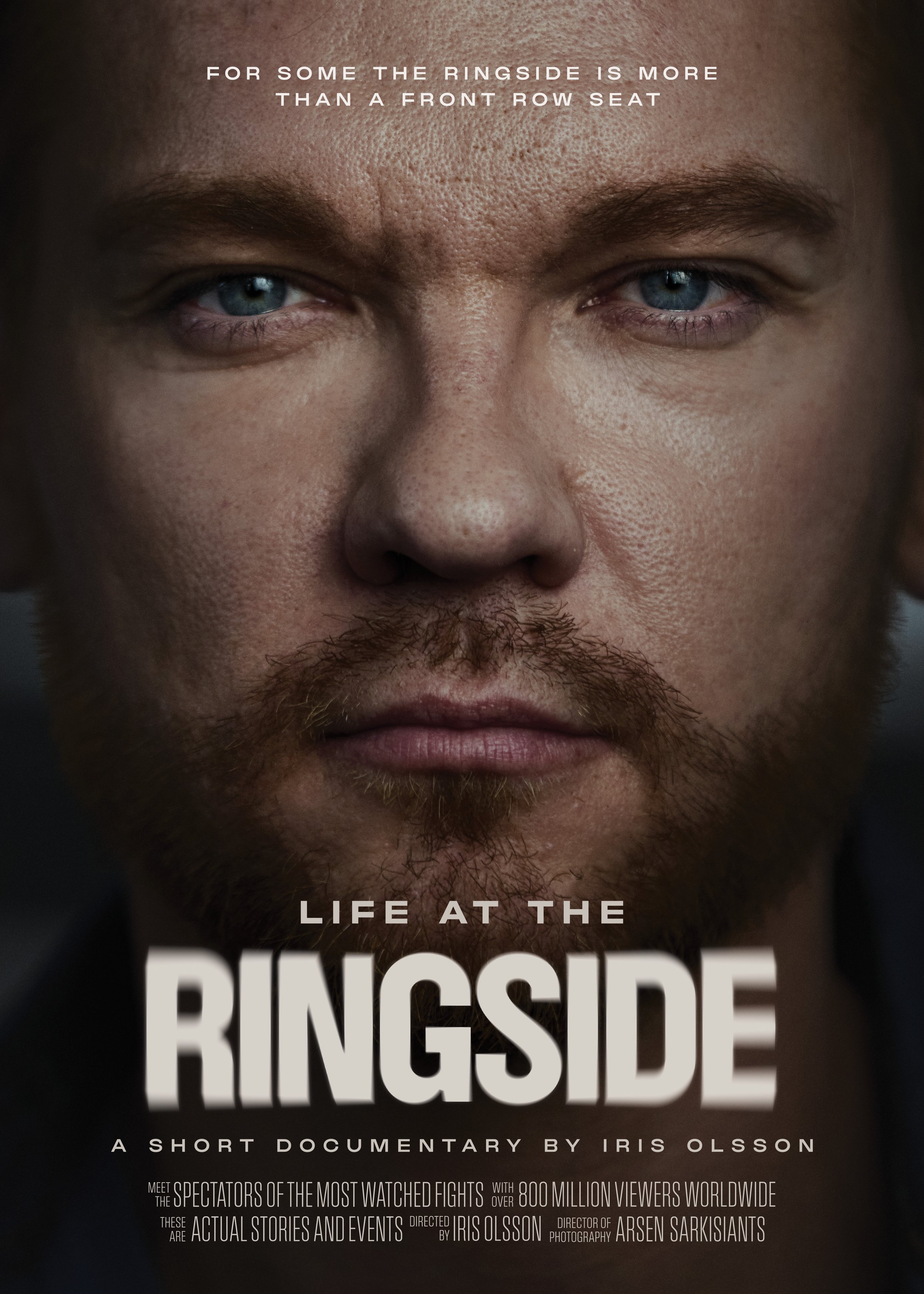 Close-up of a man's face with short hair, light skin, and blue eyes, promoting the documentary "Life at the Ringside".