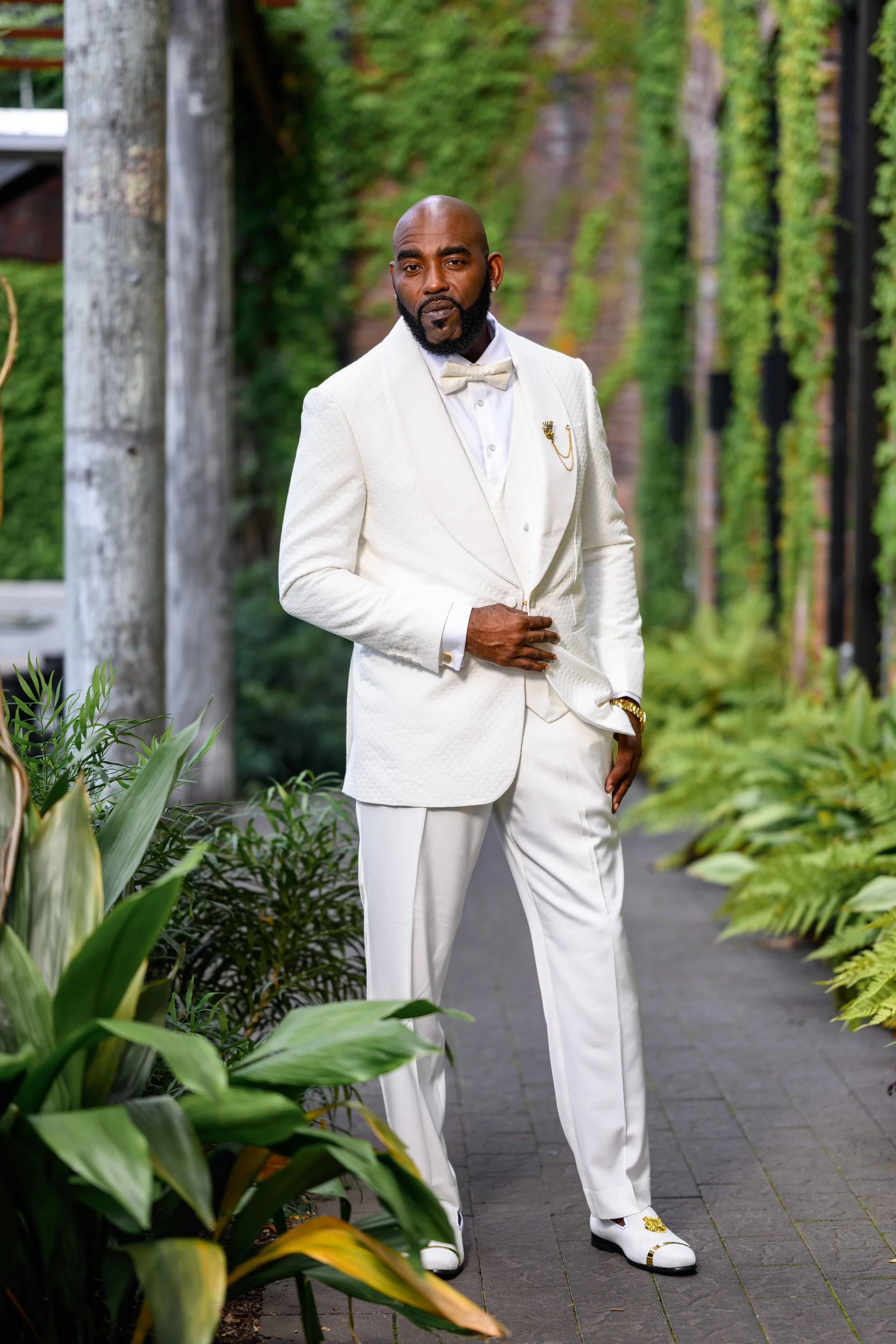 Groom in a white suit photographed before his Georgian Hall wedding.