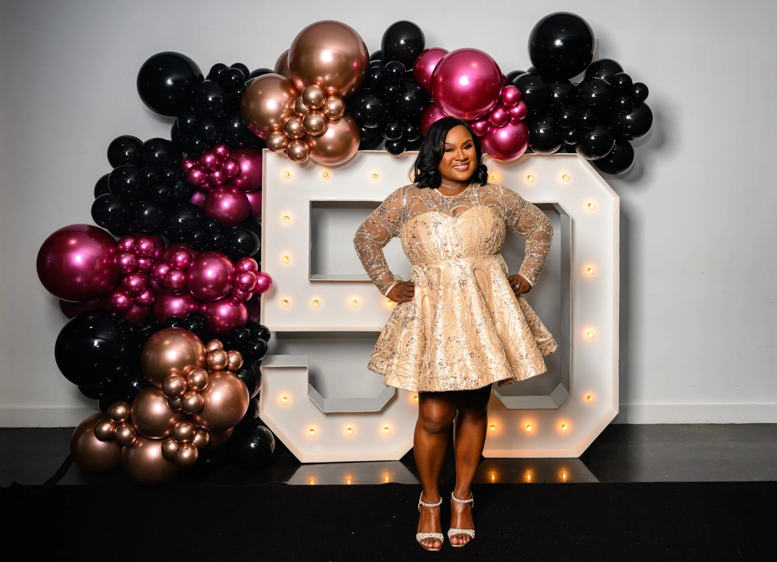 Woman celebrating her 50th birthday at Ventanas in Atlanta with balloons and light-up numbers