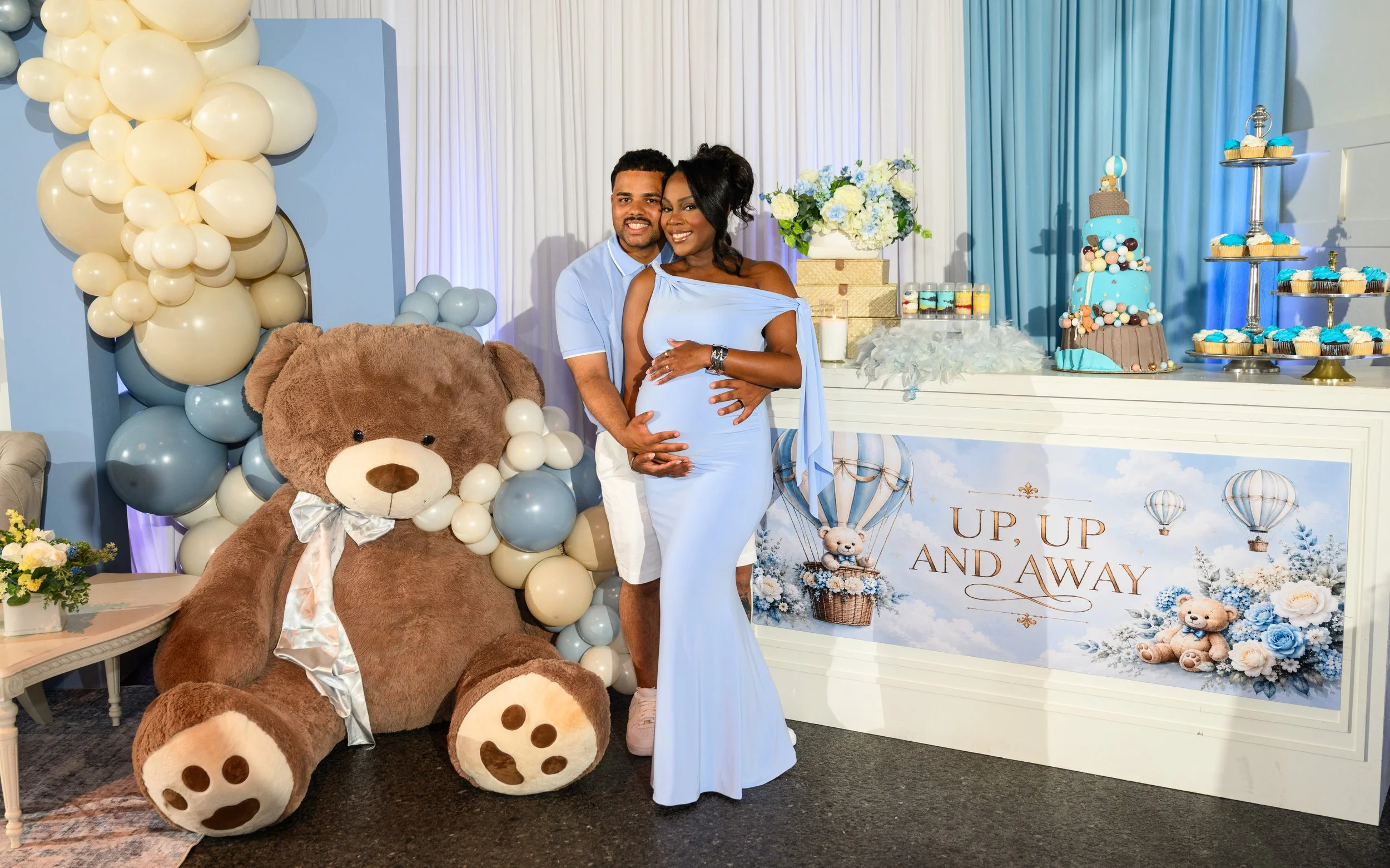 Parents-to-be posing together during their Up, Up and Away baby shower in Flowery Branch, Georgia.