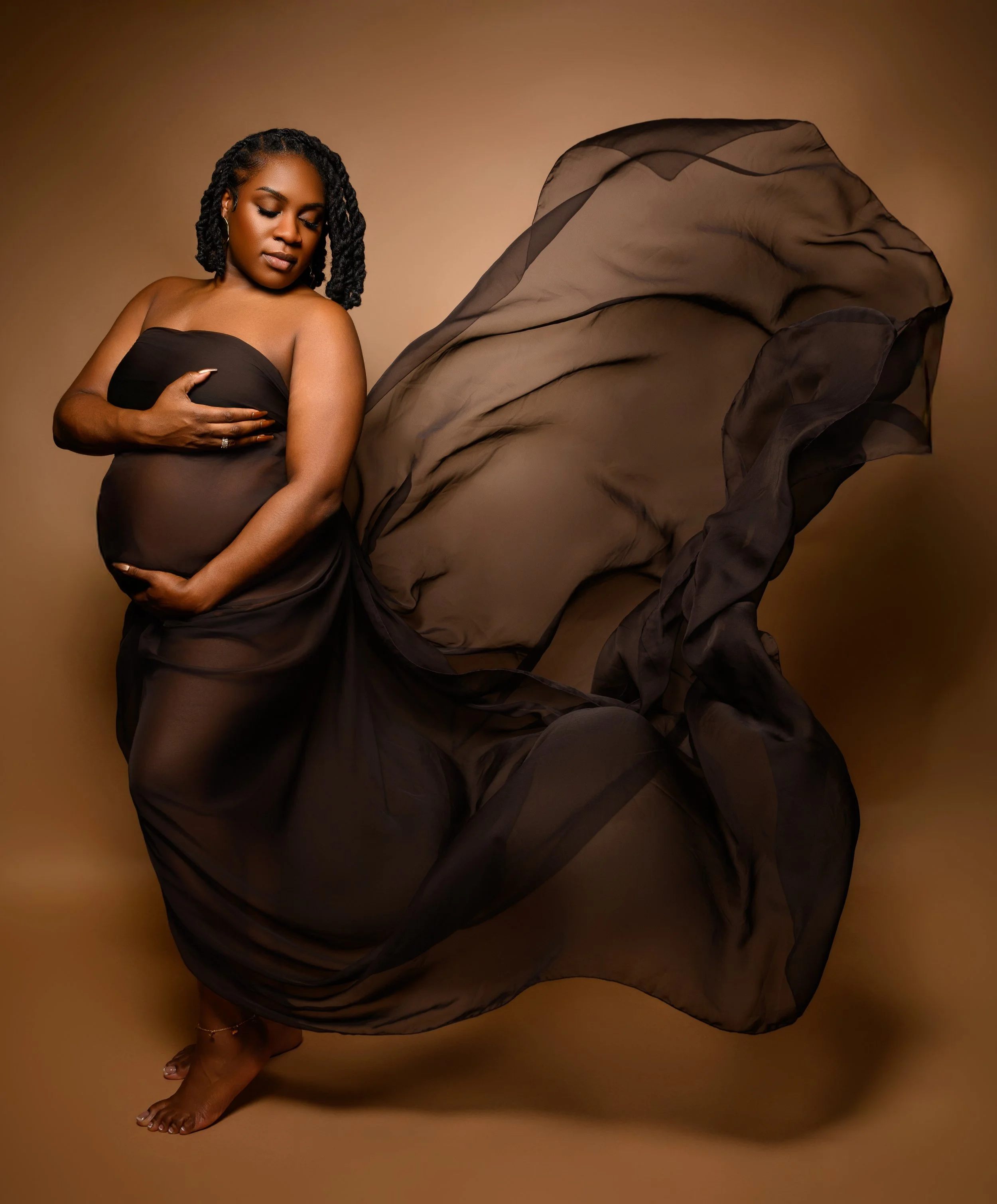 Expectant mother poses in a flowing brown gown during an editorial maternity photography session in Atlanta.