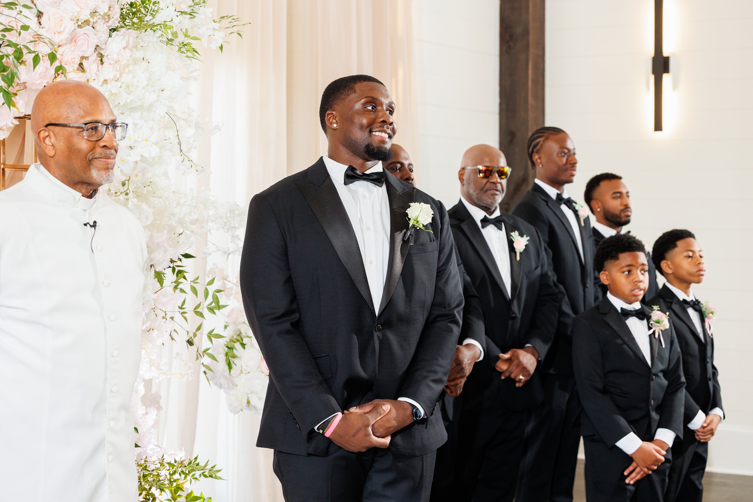 Groom smiling as he watches his bride during their wedding ceremony at The Venue at Daisy Hill.