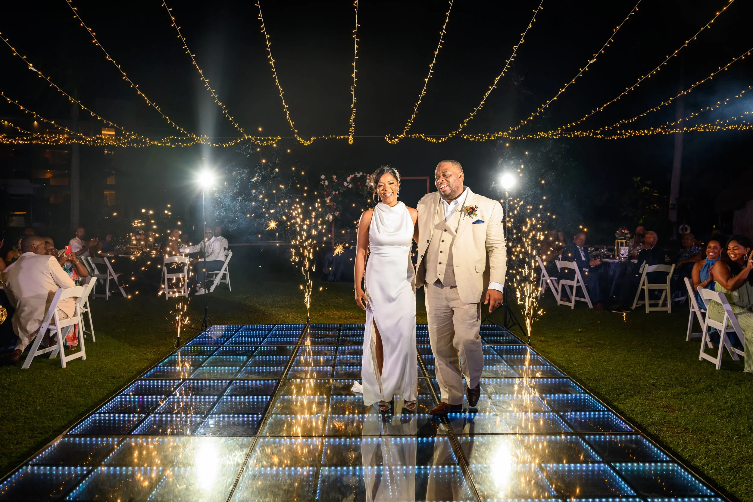 Tekla and Rick celebrating on the illuminated dance floor during their Cancun wedding reception.