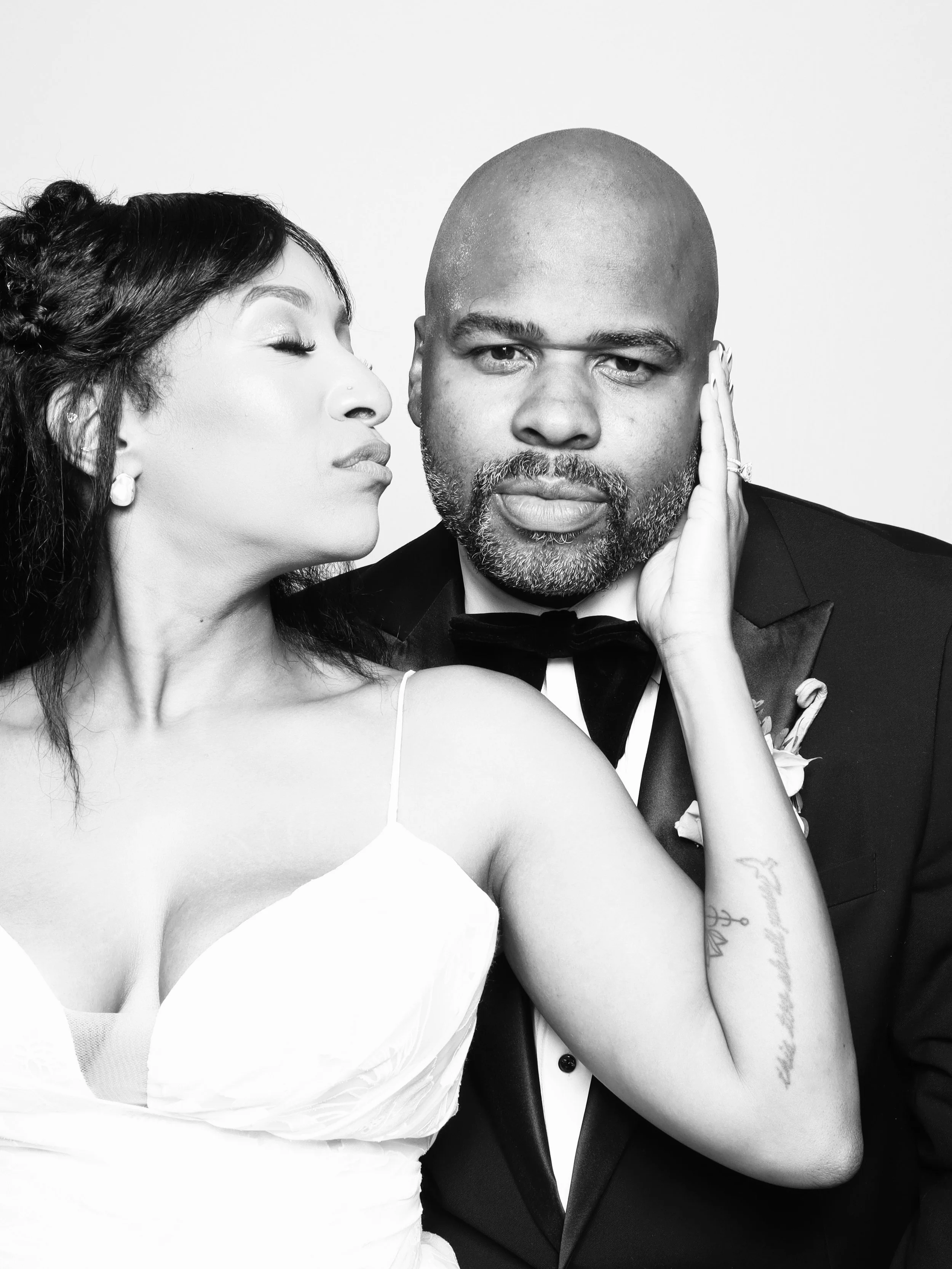 Couple shares a playful moment during a black-and-white portrait session.