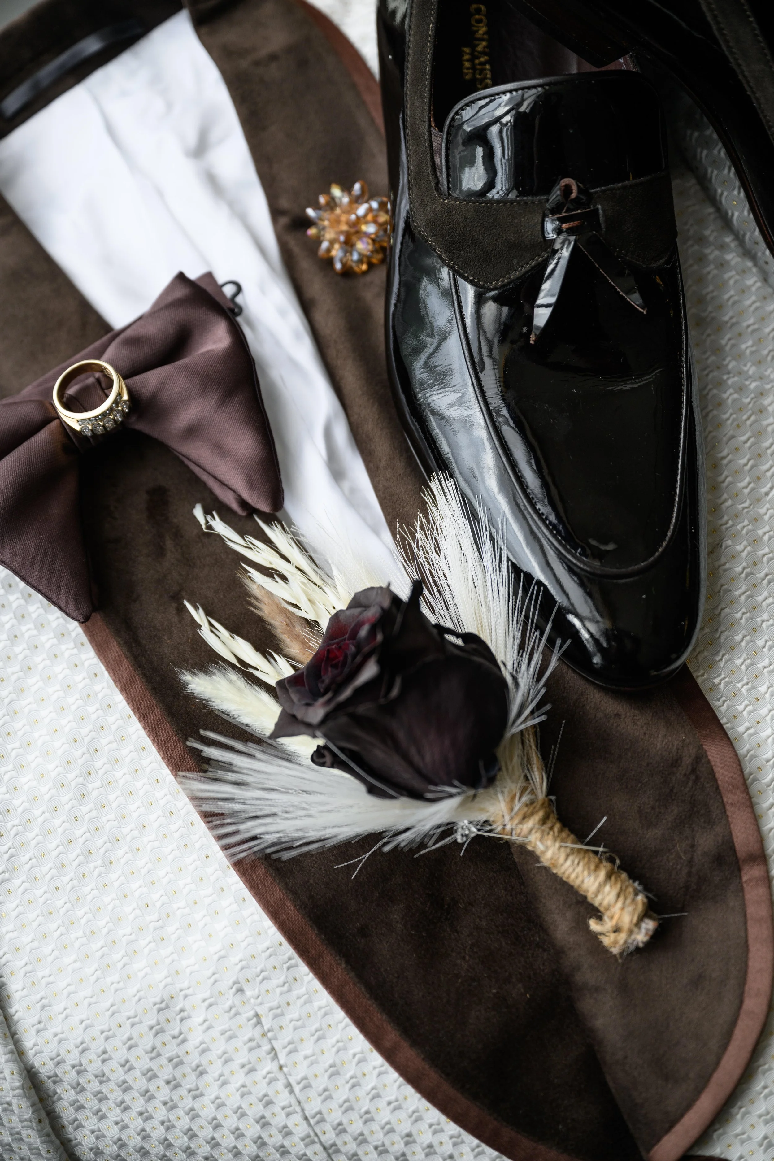 Groom's shoes, bow tie, boutonniere and accessories arranged before the wedding at Shahbain Events Center.