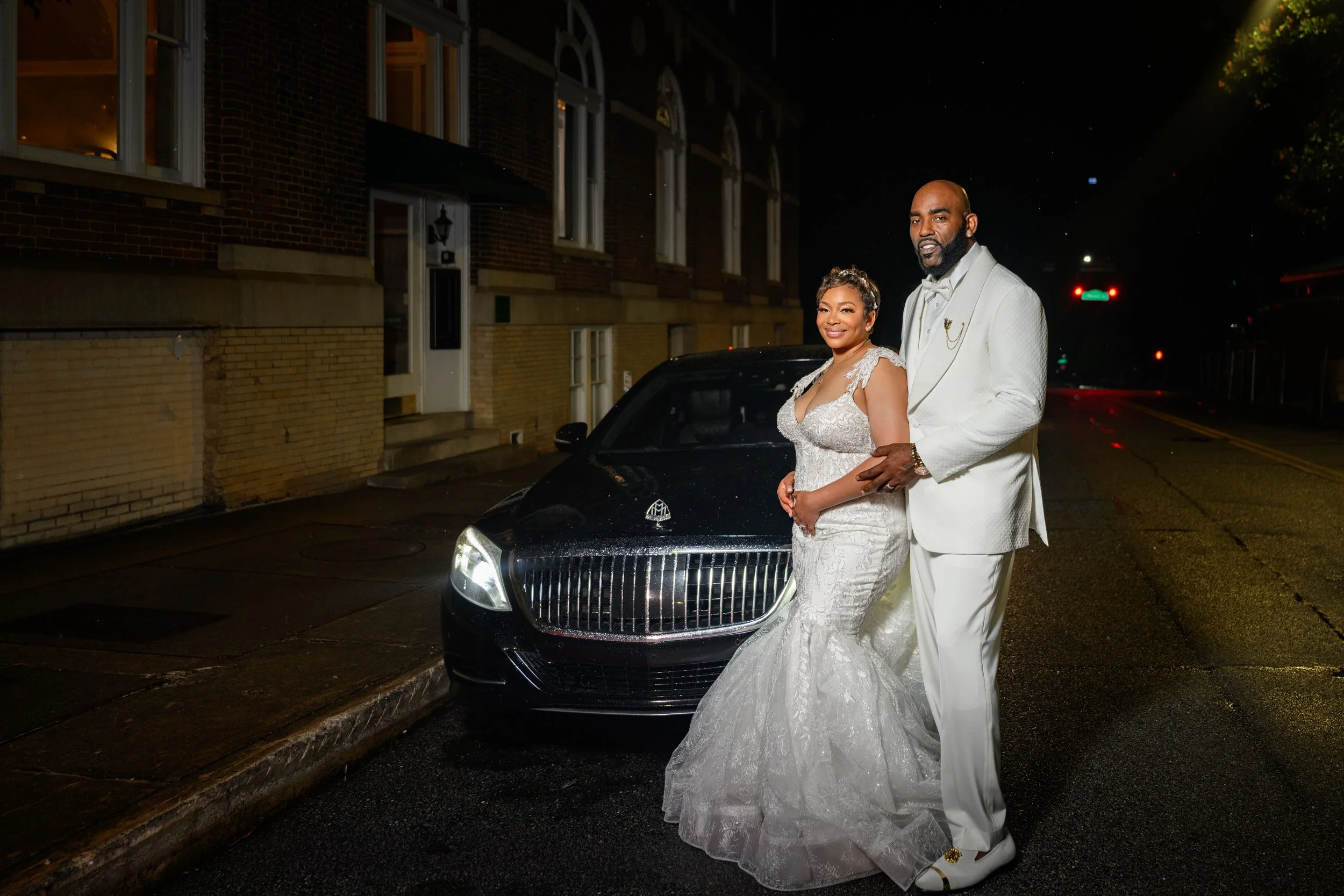 Sherod and Sonya photographed beside a car at night after their Georgian Hall wedding celebration.