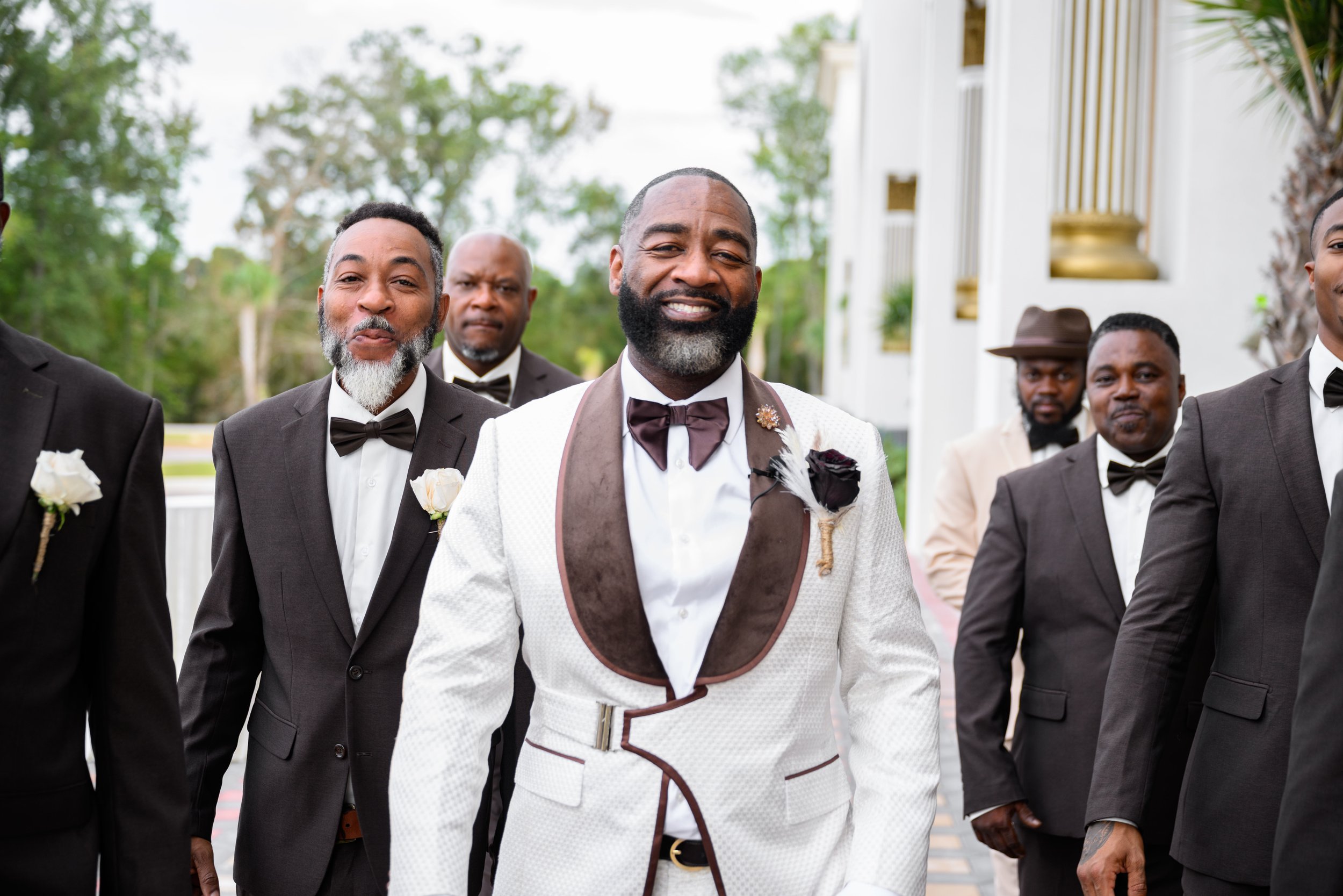 Groom walking outdoors with his groomsmen on his wedding day at Shahbain Events Center.