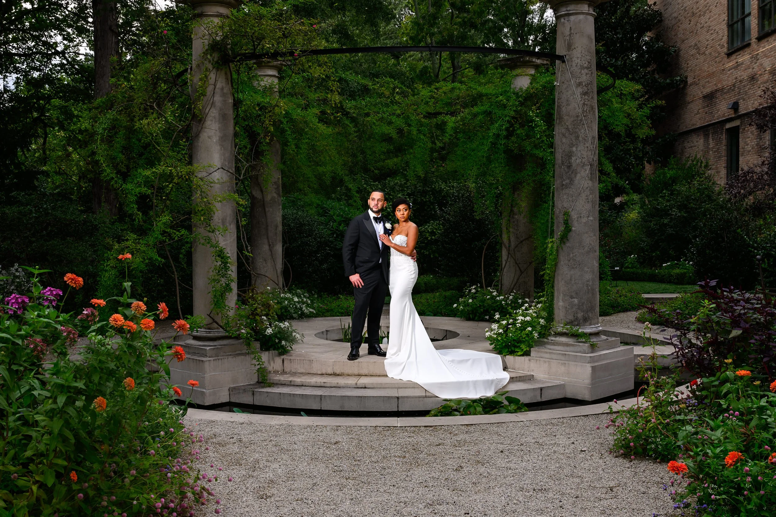 Bride and groom surrounded by lush greenery and flowers during their Atlanta wedding portraits.