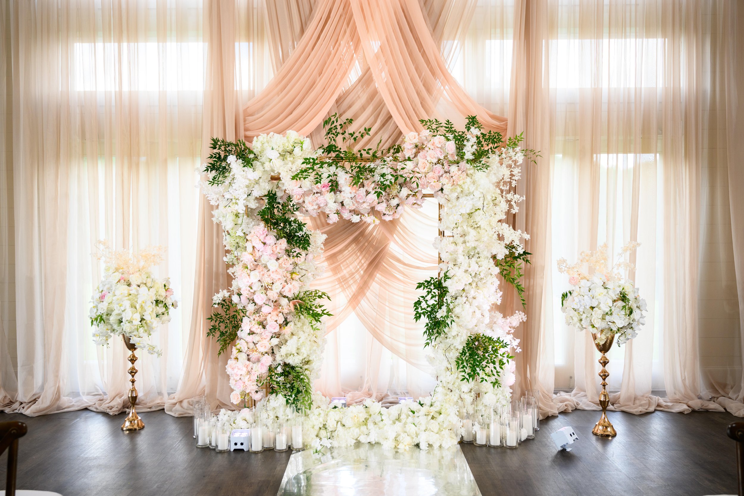 Pink and white floral ceremony installation with soft draping at The Venue at Daisy Hill.