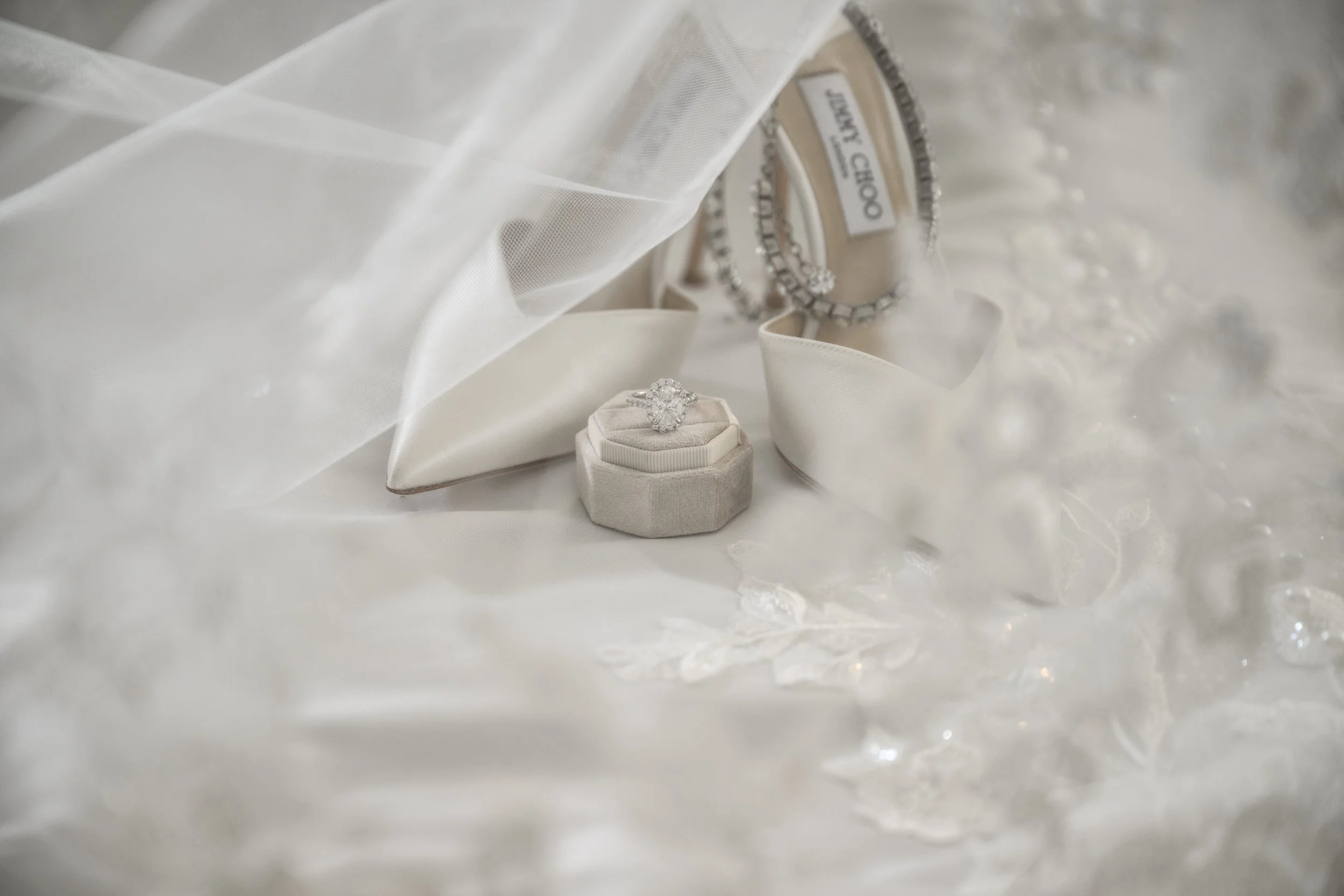 Jimmy Choo bridal shoes and wedding ring styled with the bride’s veil and lace gown details.