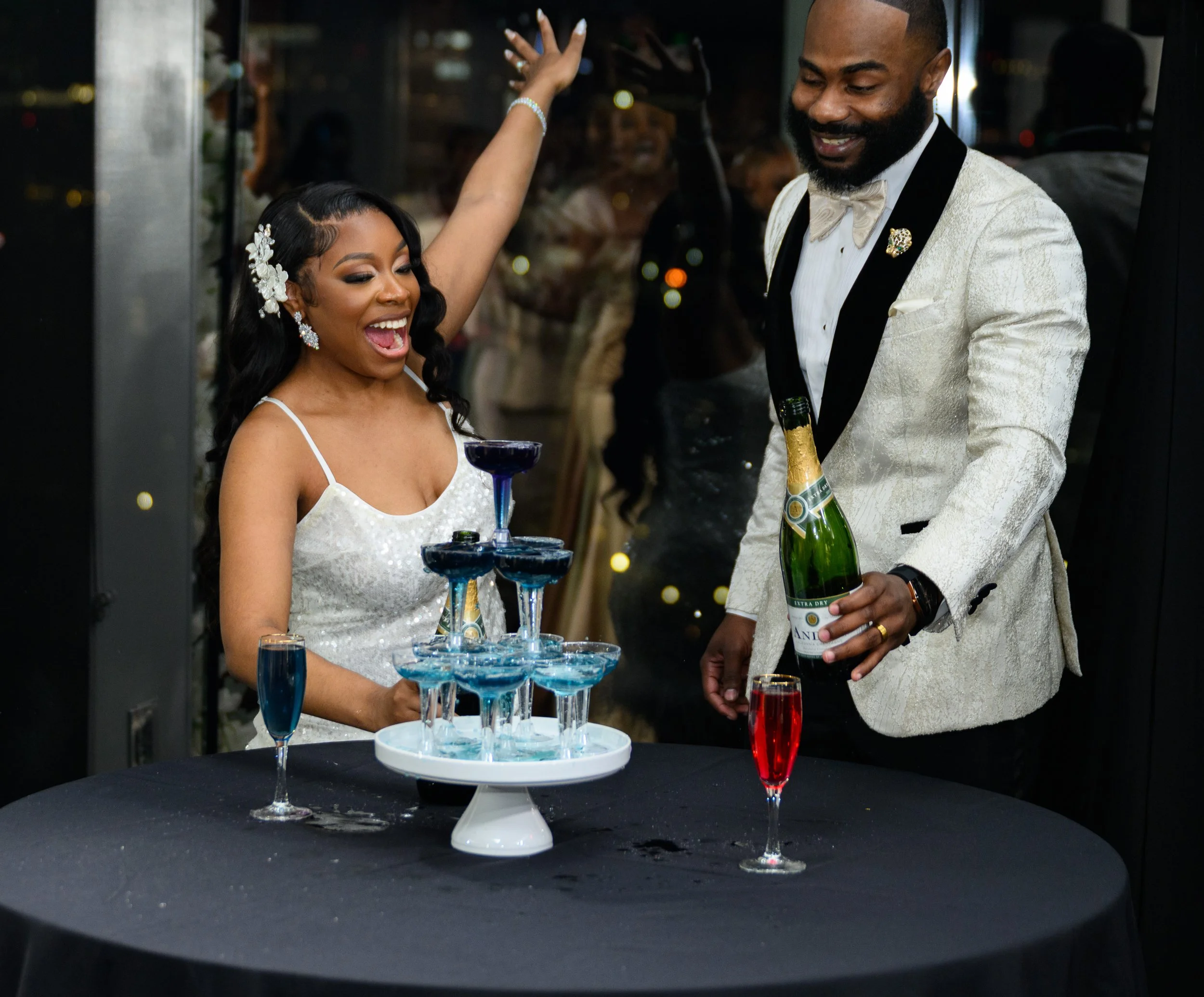 Shareze and Jacorey celebrating their baby announcement with family and friends during their wedding reception.
