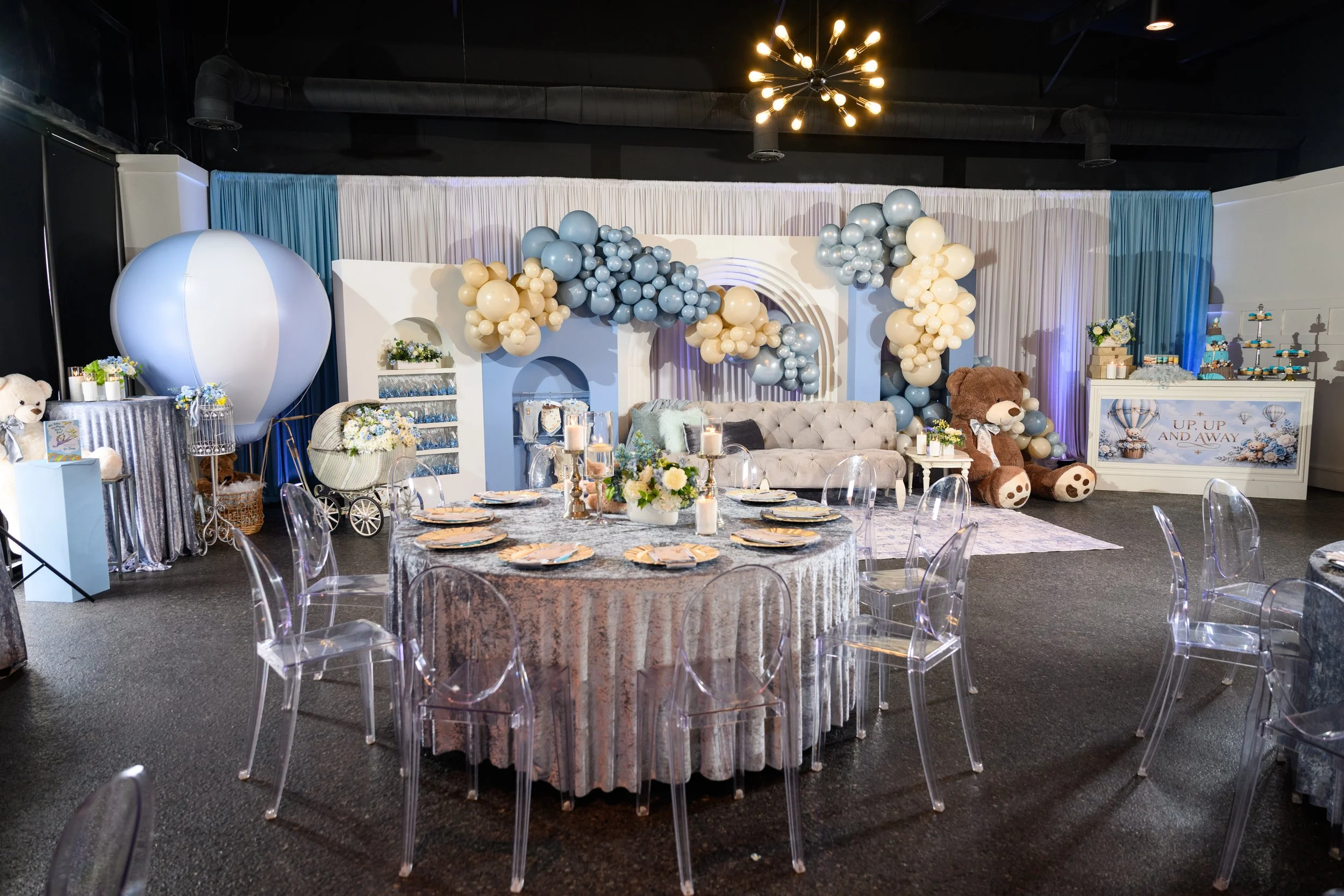 Blue and cream Up, Up and Away baby shower setup with balloons, florals and decorated tables in Flowery Branch, Georgia.
