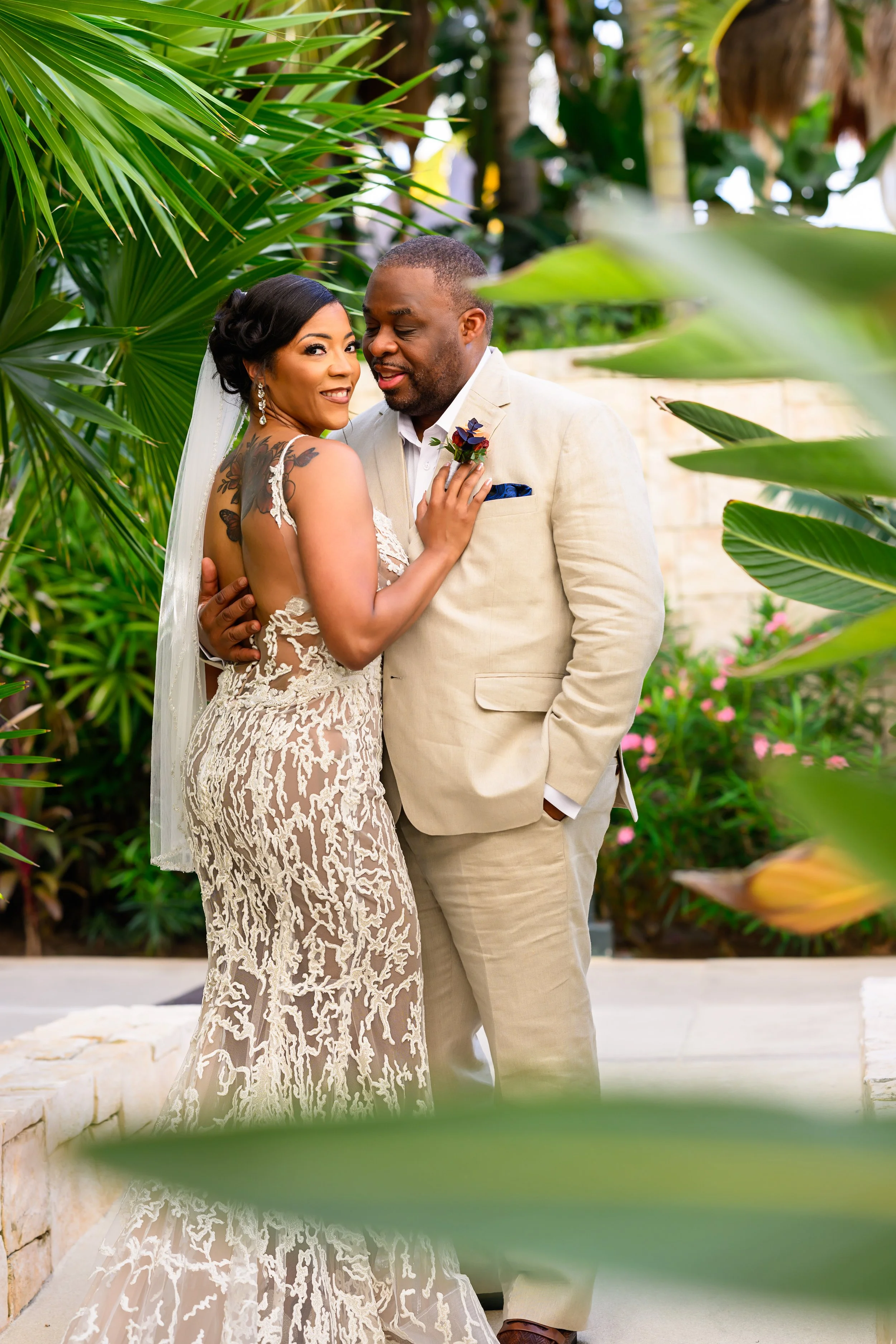 Tekla and Rick surrounded by tropical greenery on their wedding day in Cancun, Mexico.