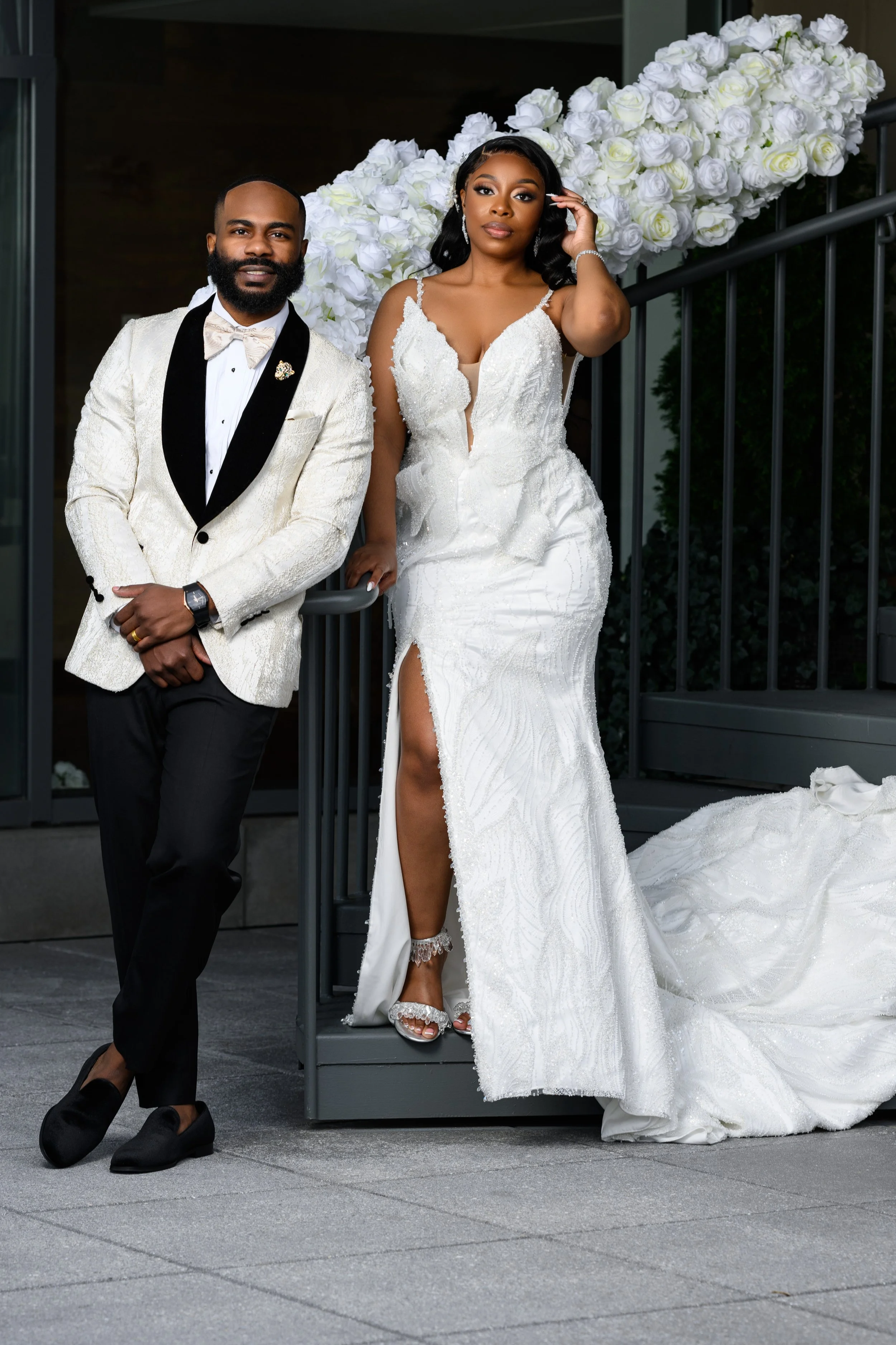 Shareze and Jacorey posing together beside white florals during their wedding at Ventanas in Atlanta.