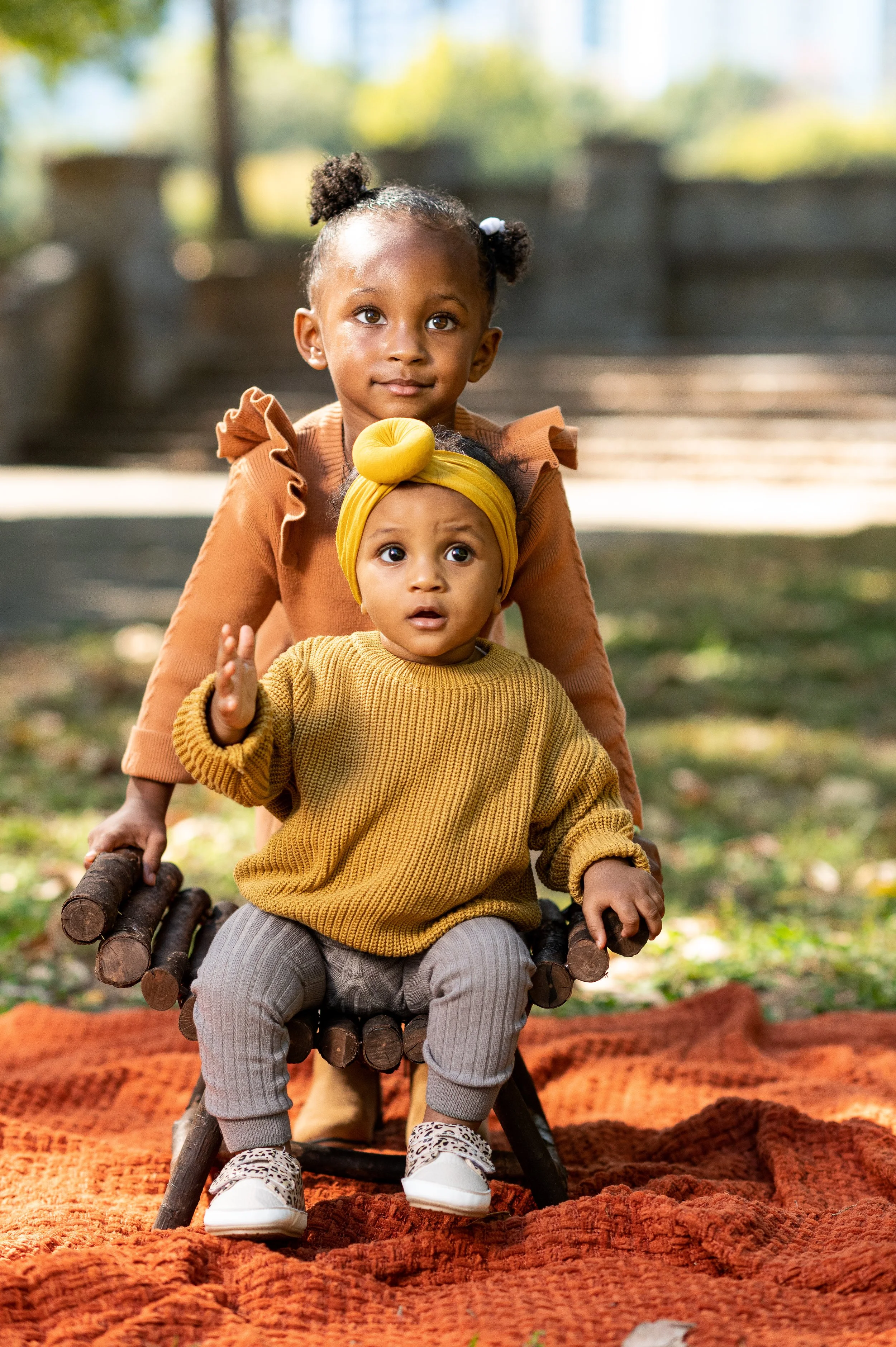 Two young sisters posing together during a family photography session at Piedmont Park in Atlanta.