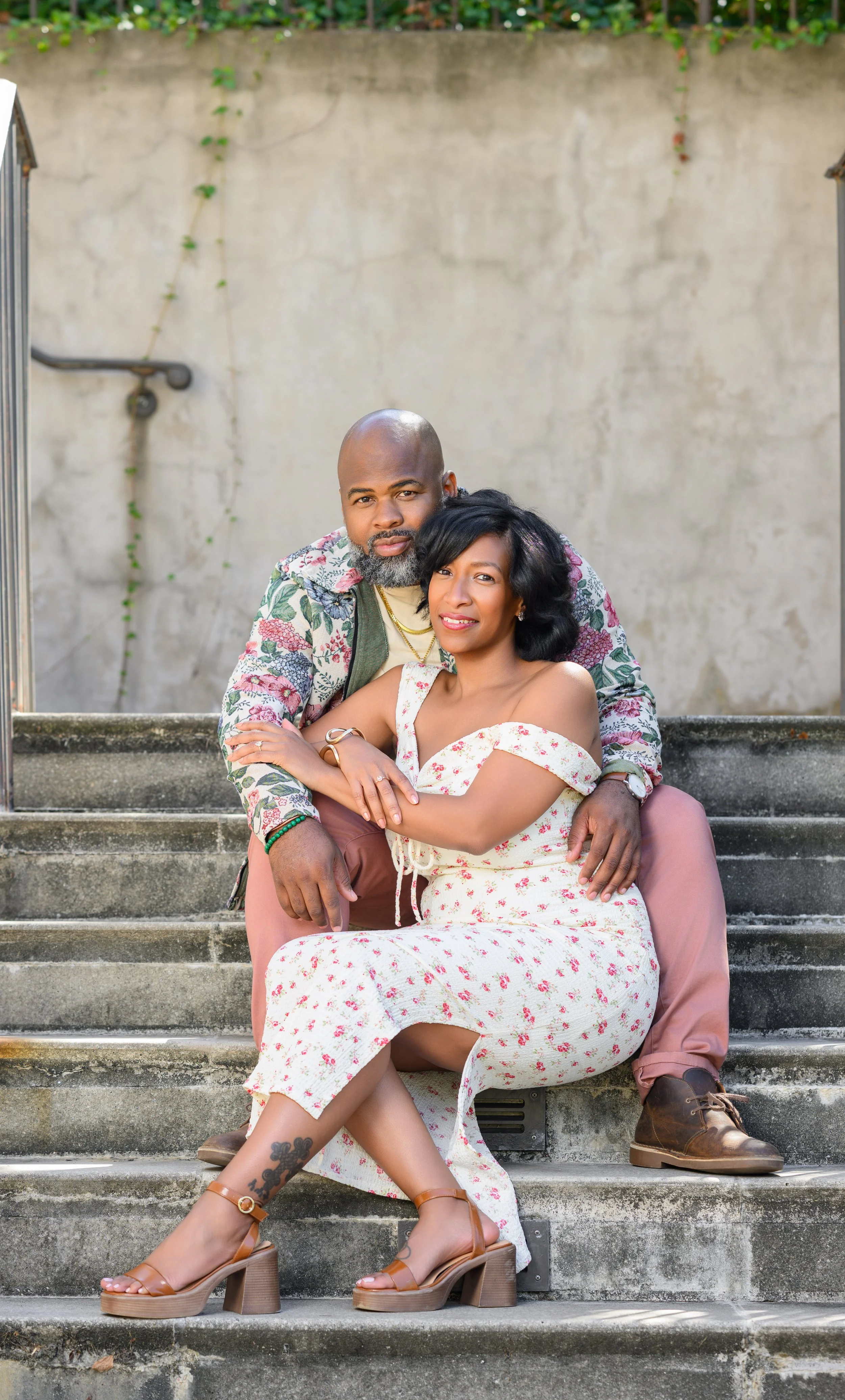 Jessica and Steven sitting together on the steps at Millennium Gate Museum during their engagement session.