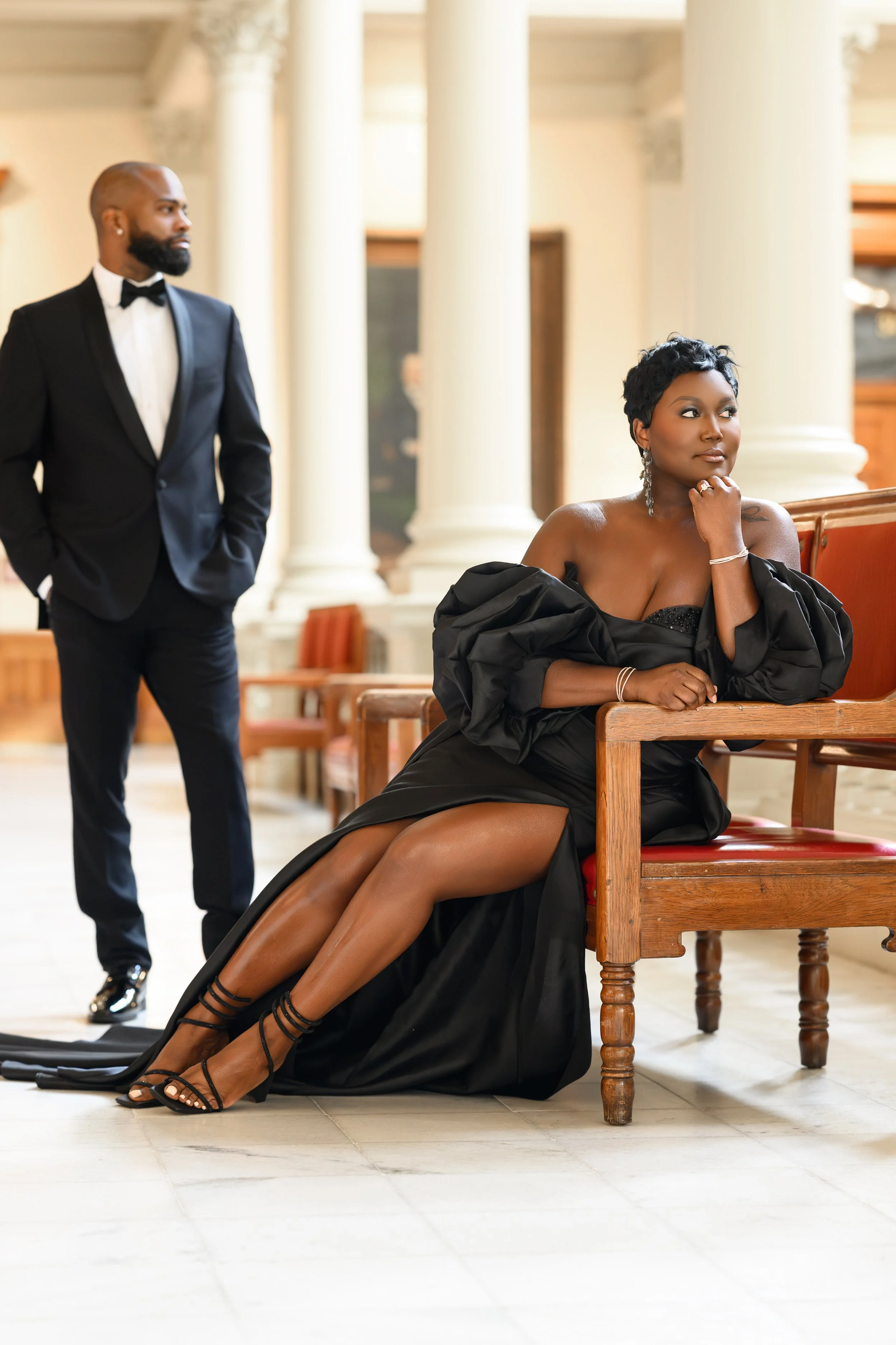 Engaged couple in black formal attire posing inside the Georgia State Capitol in Atlanta.