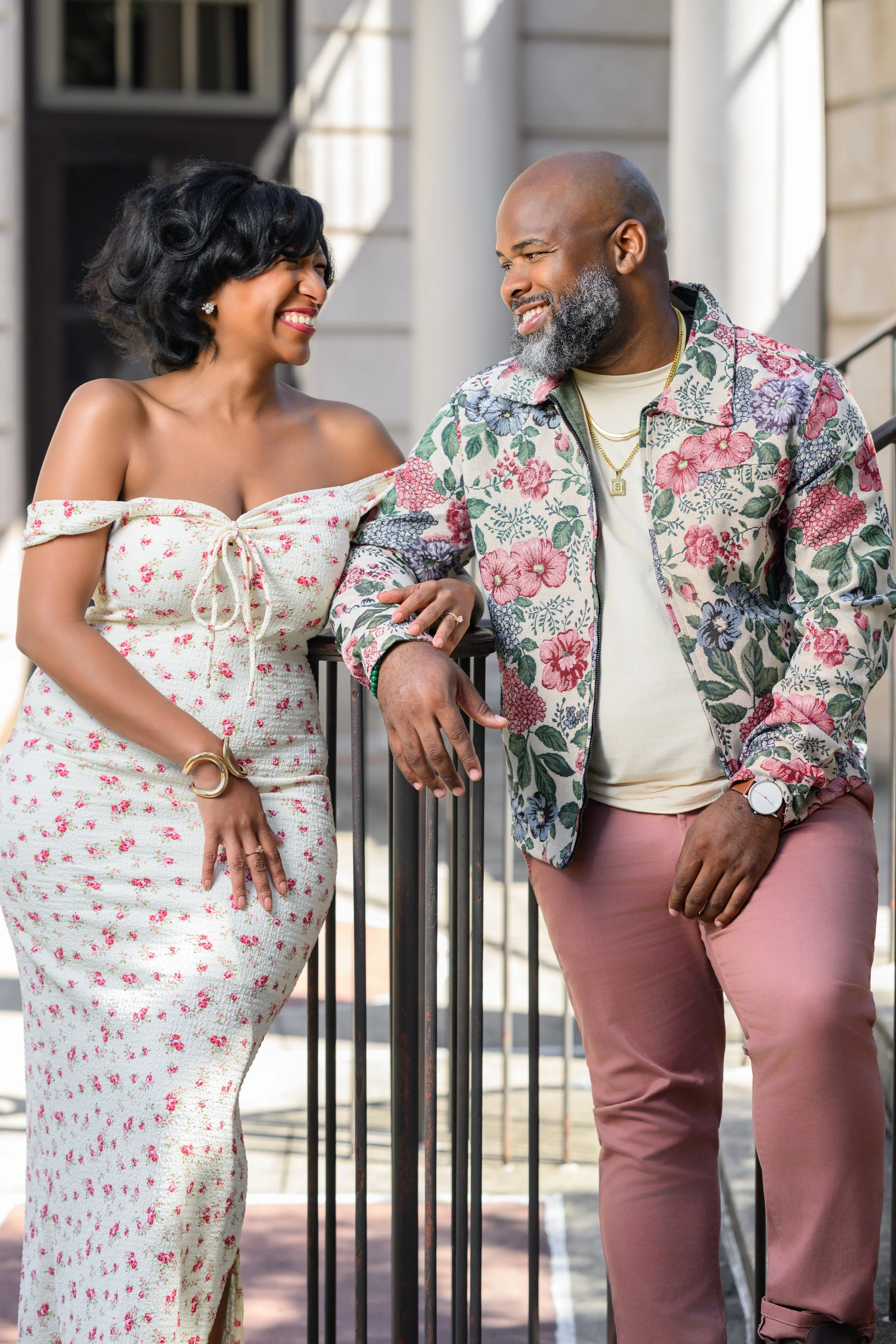 Engaged couple sharing a playful moment beside the railing at Millennium Gate Museum in Atlanta.