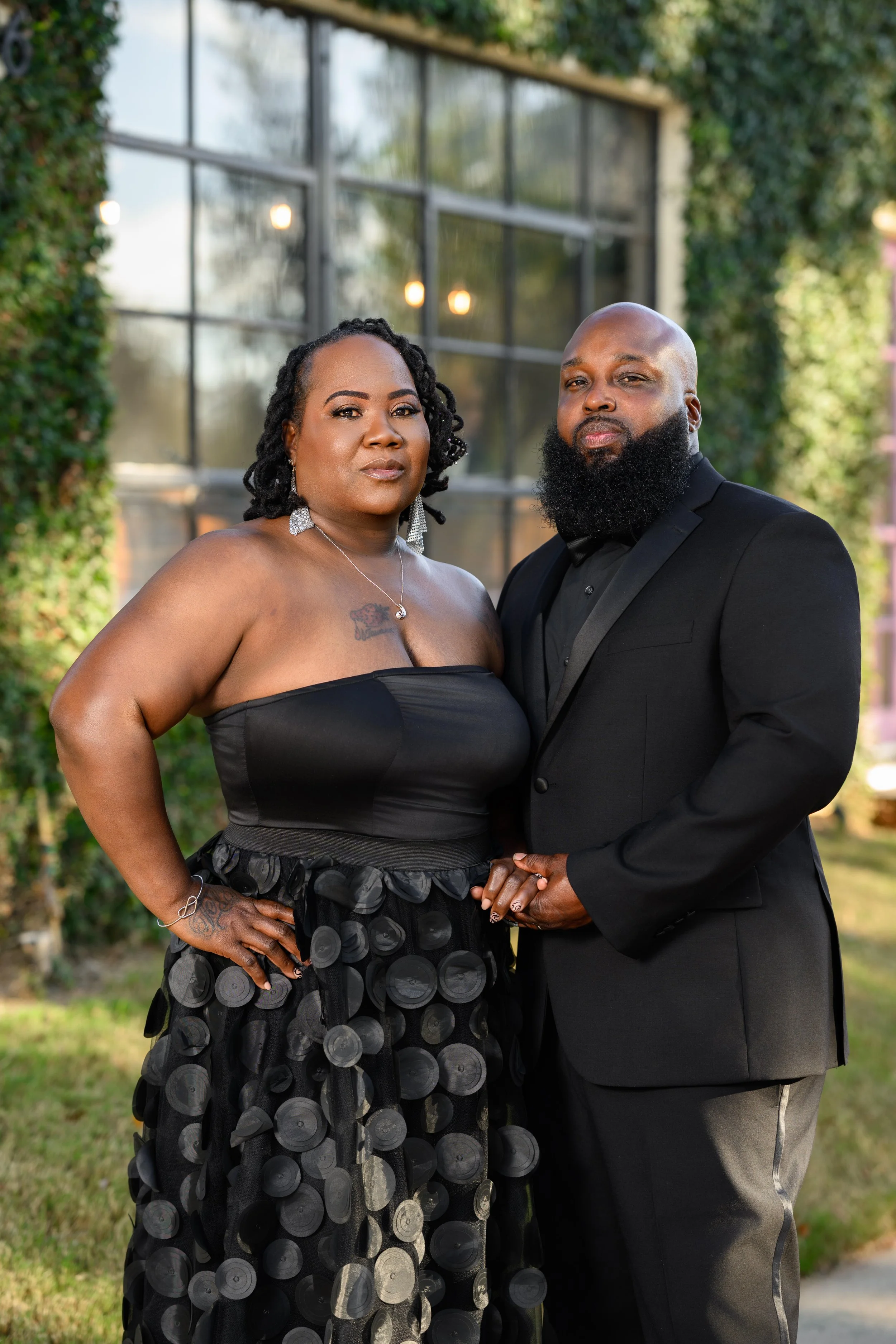 Couple posing together near ivy and industrial windows during a McDonough, Georgia portrait session.