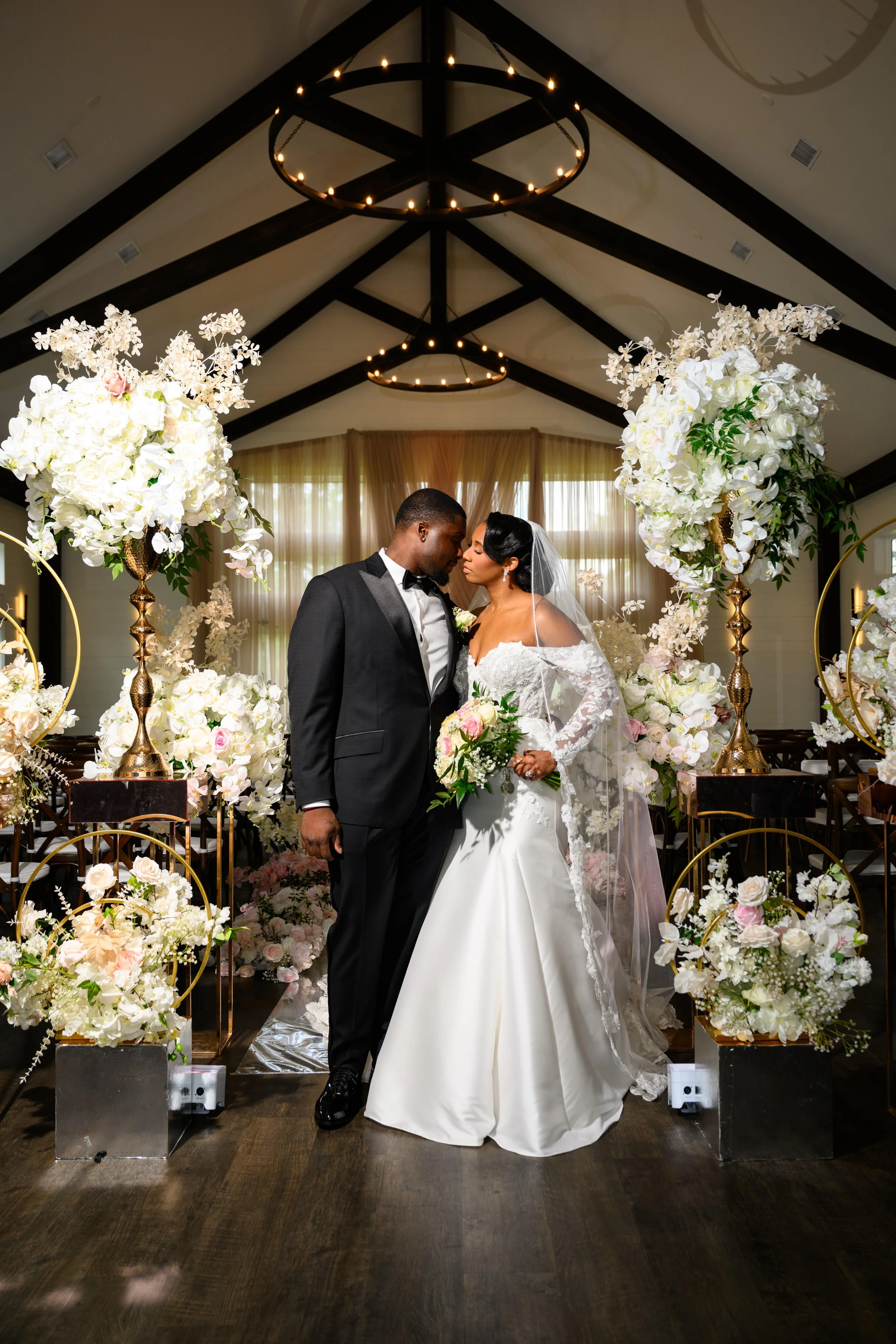 Bride and groom sharing an intimate portrait surrounded by white and blush wedding florals at The Venue at Daisy Hill.